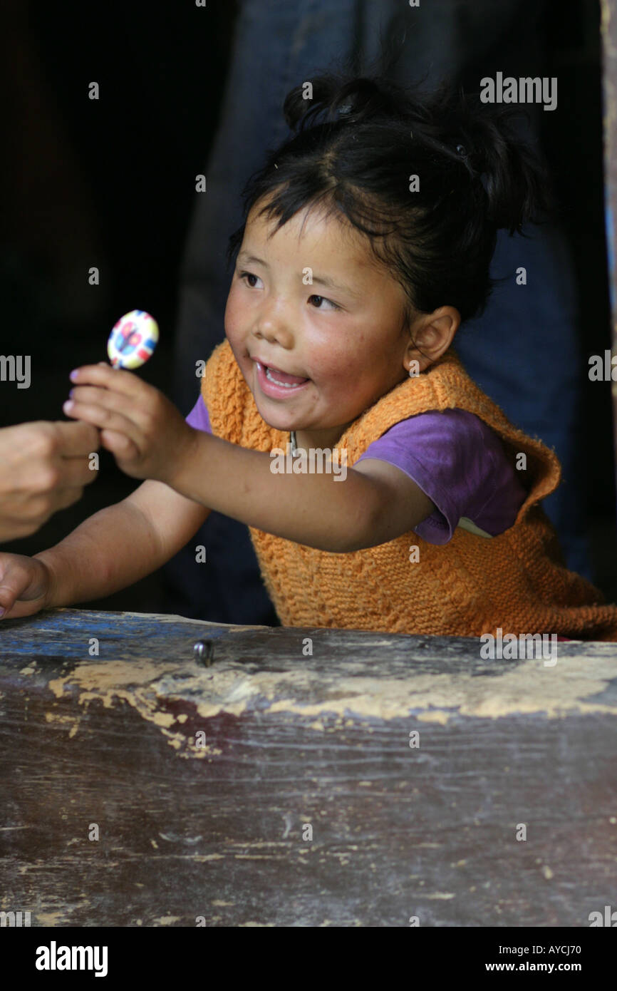 Una piccola ragazza ottenendo un lecca-lecca, Ladakh Foto Stock