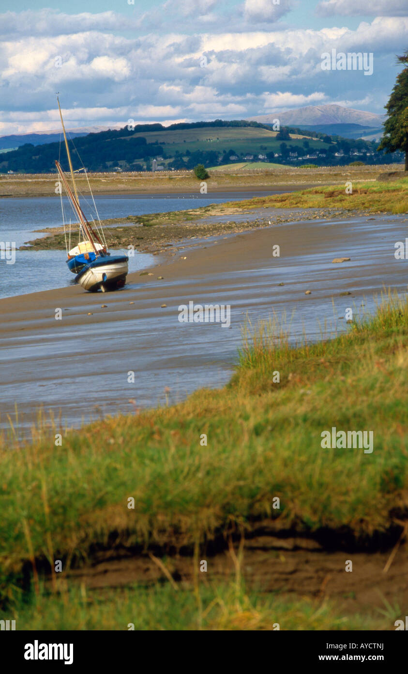 Barche giacciono sulle sabbie della carriola estuario su una soleggiata giornata estiva con il Distretto del Lago colline in background Foto Stock