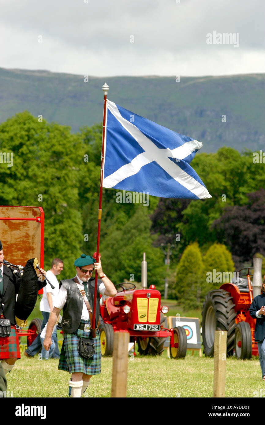 Kilted portabandiera con Scottish si intraversa bandiera Foto Stock