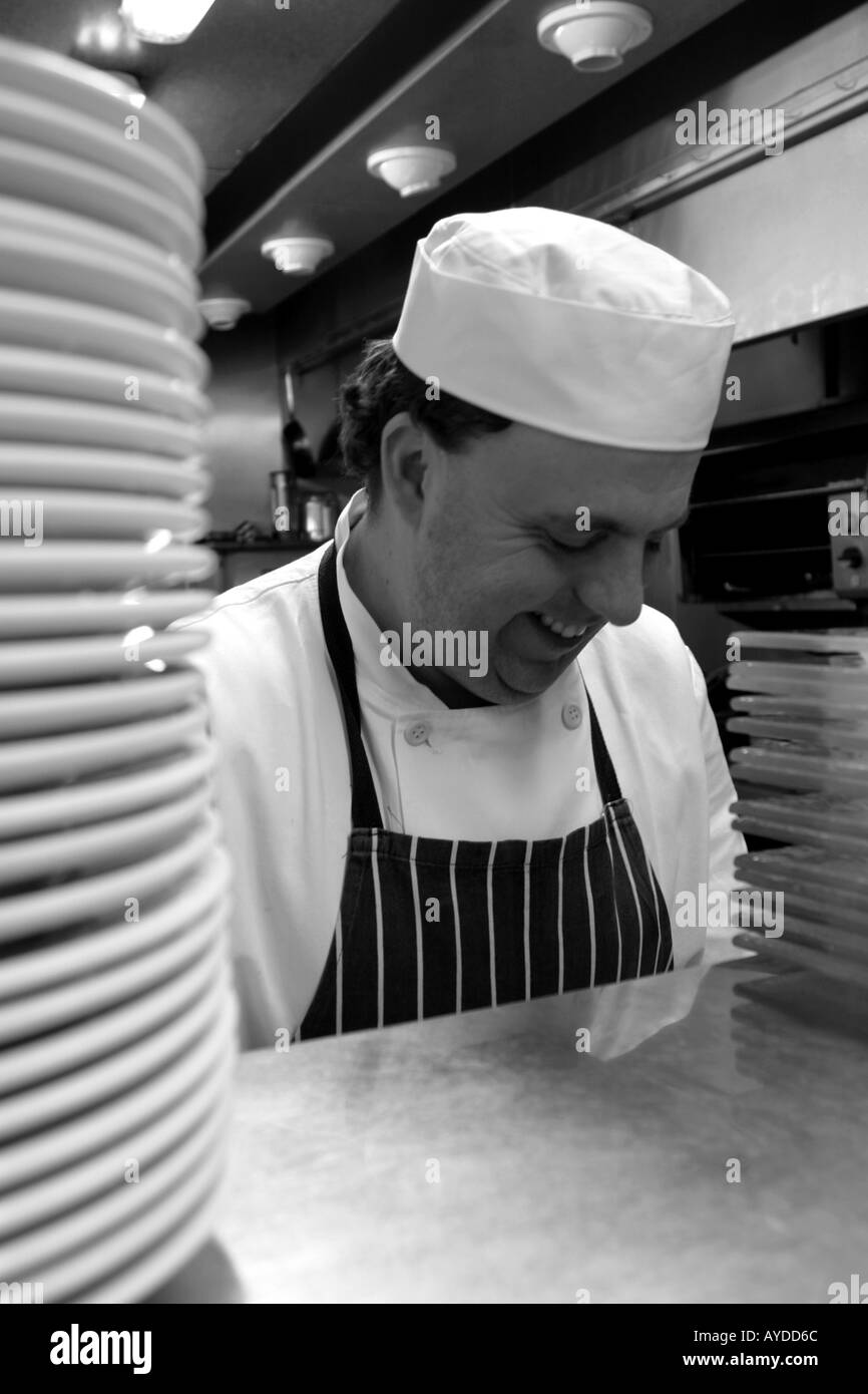 Lo chef prepara il cibo in un ristorante di cucina Foto Stock