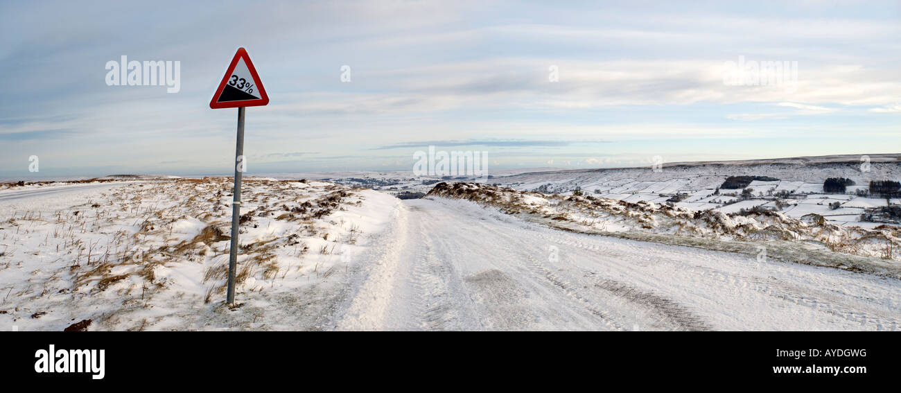 North Yorkshire Moors National Park - strada coperta di neve in inverno sopra Danby Dale. Foto Stock