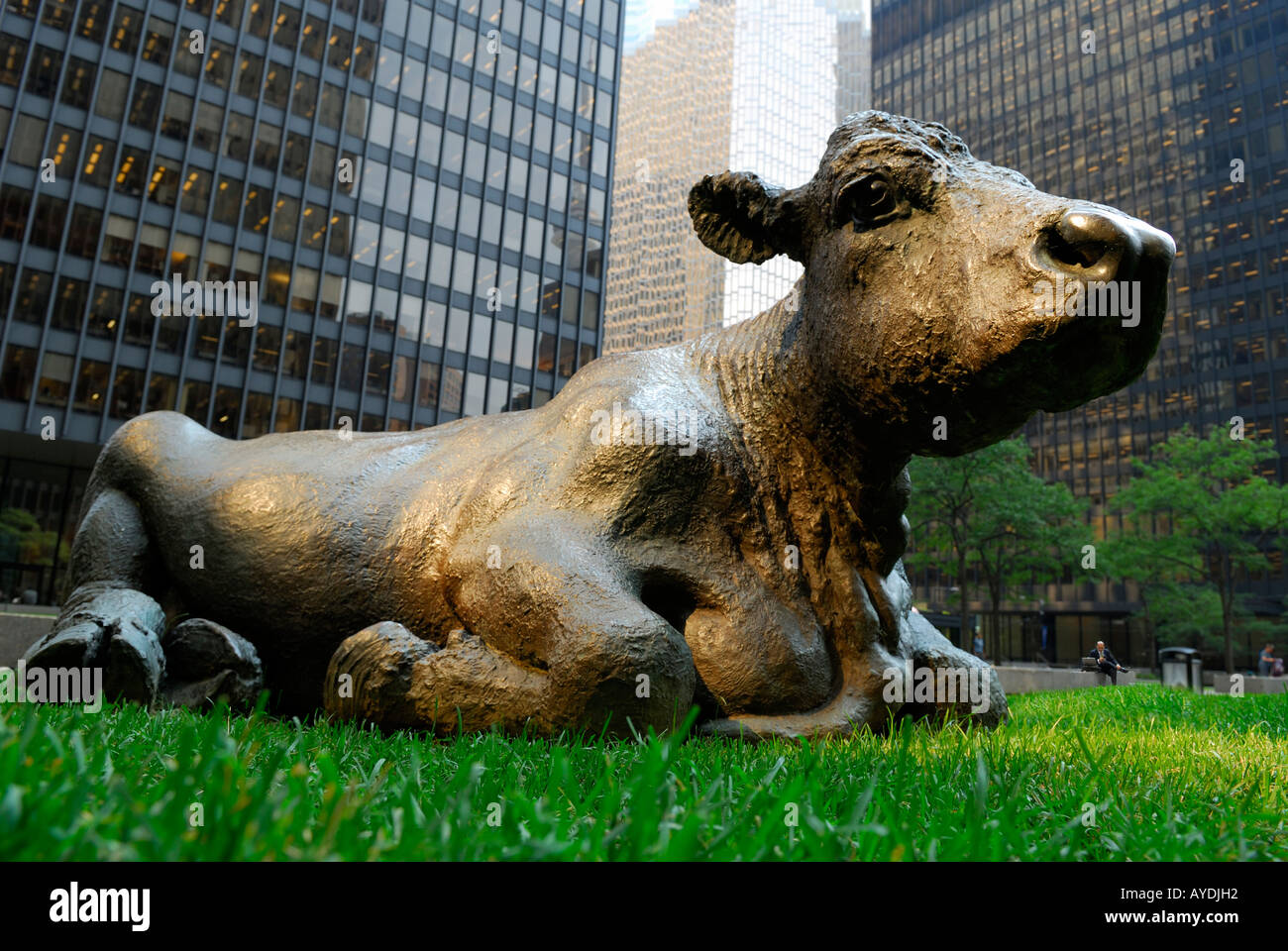 Toro in bronzo scultura giacente in erba tra banca e torri di imprenditore di lavoro Downtown Toronto Foto Stock