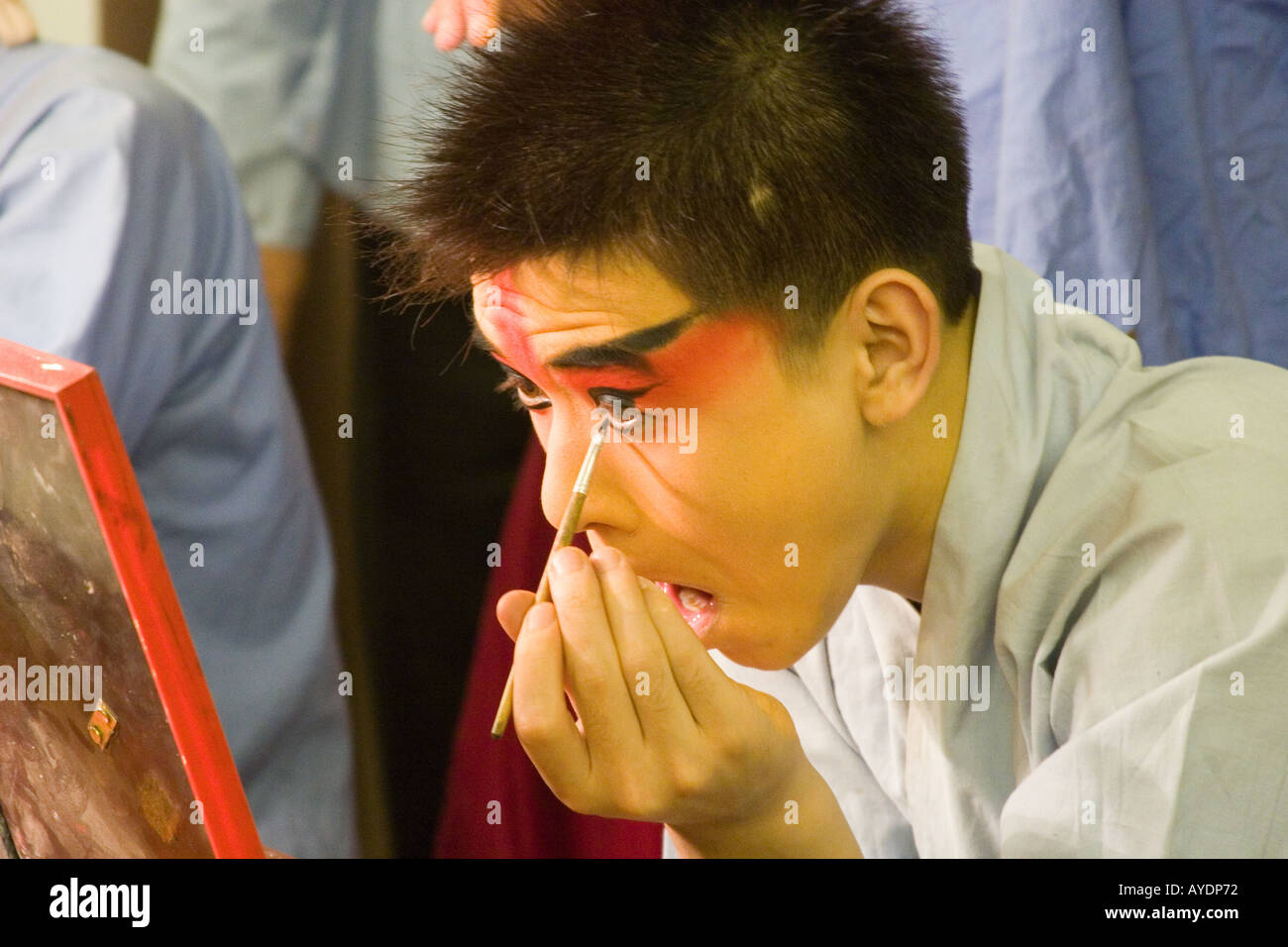 Opera di Pechino performer applicando il suo trucco in primo piano in preparazione per la sera mostra a Beijing in Cina Foto Stock