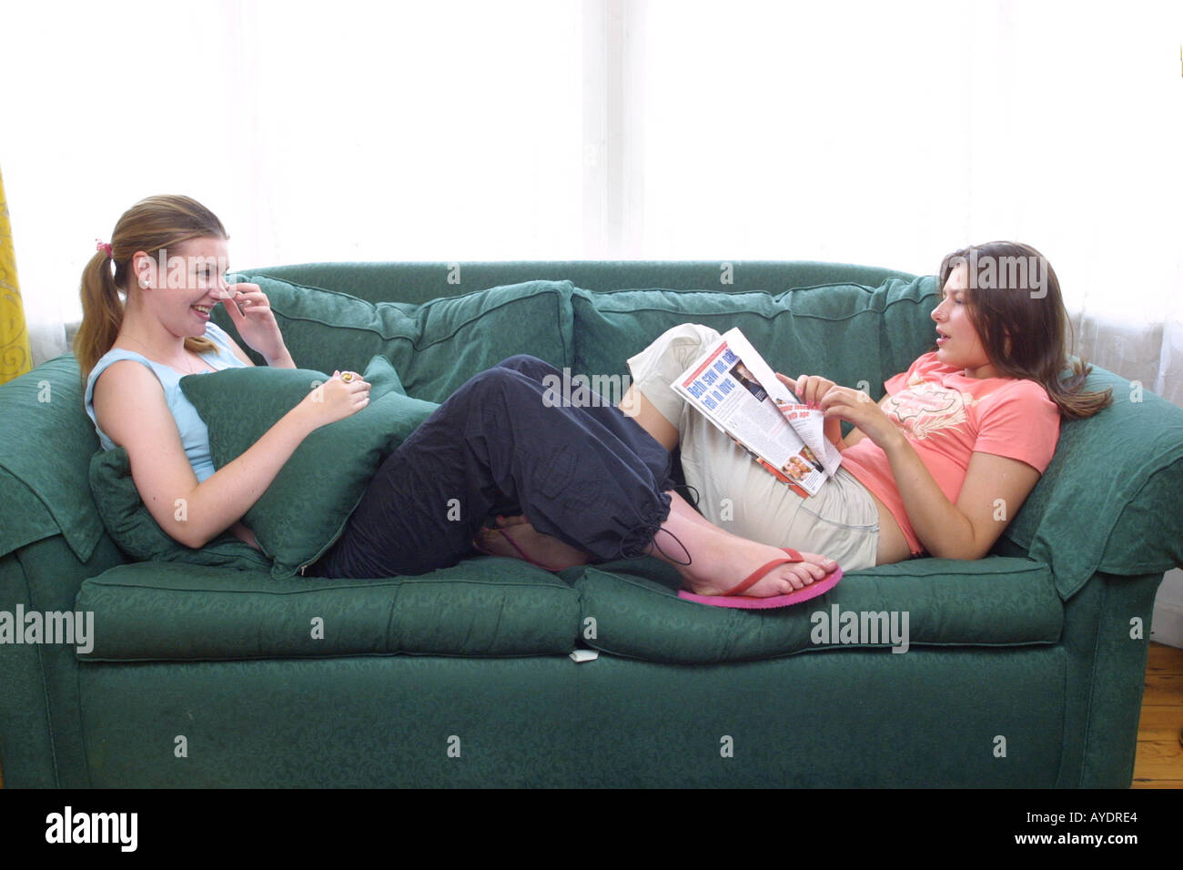 Due ragazze adolescenti sdraiata su un lettino e in chat Foto Stock