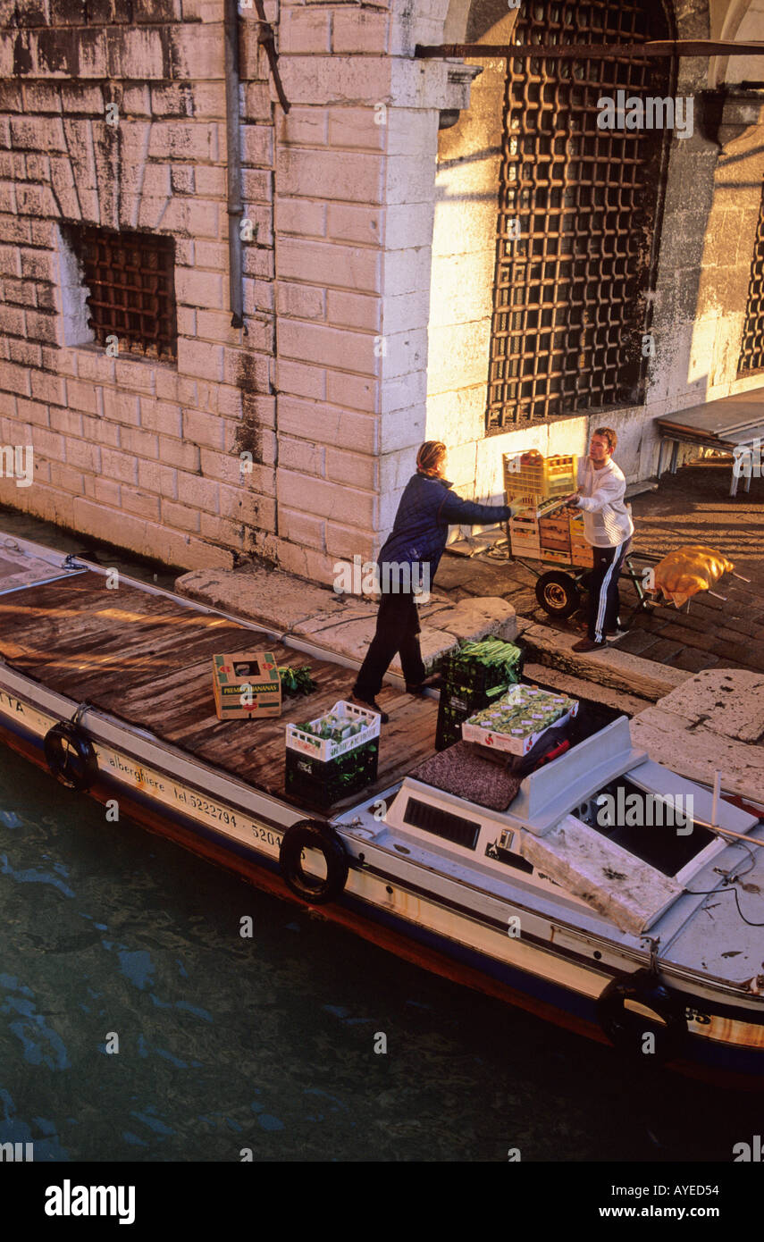 Consegna uomini che scaricano una chiatta di cibo fresco di fronte alla prigione Venezia Italia Foto Stock