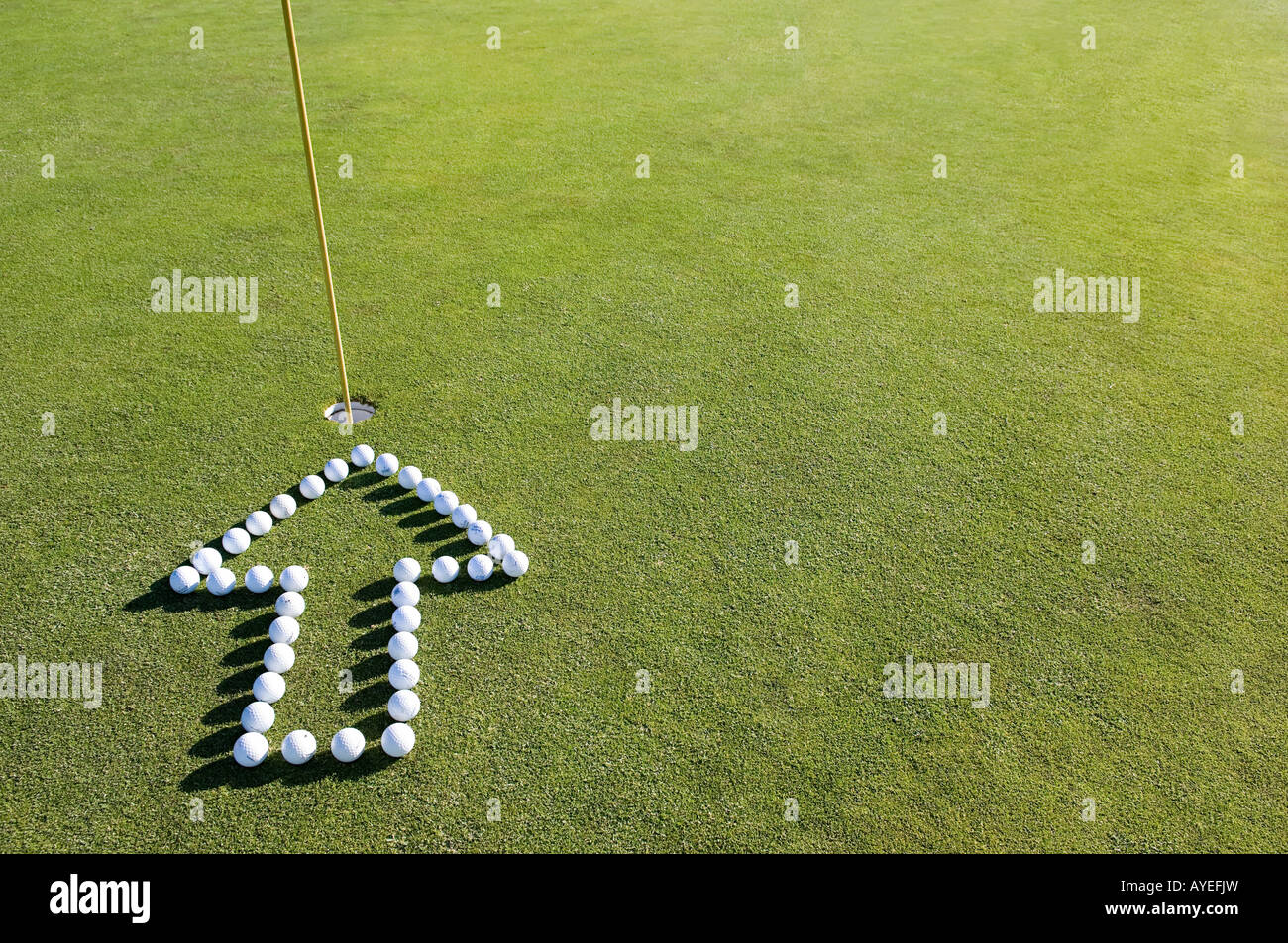 Una freccia rivolta verso il foro su un golf green Foto Stock