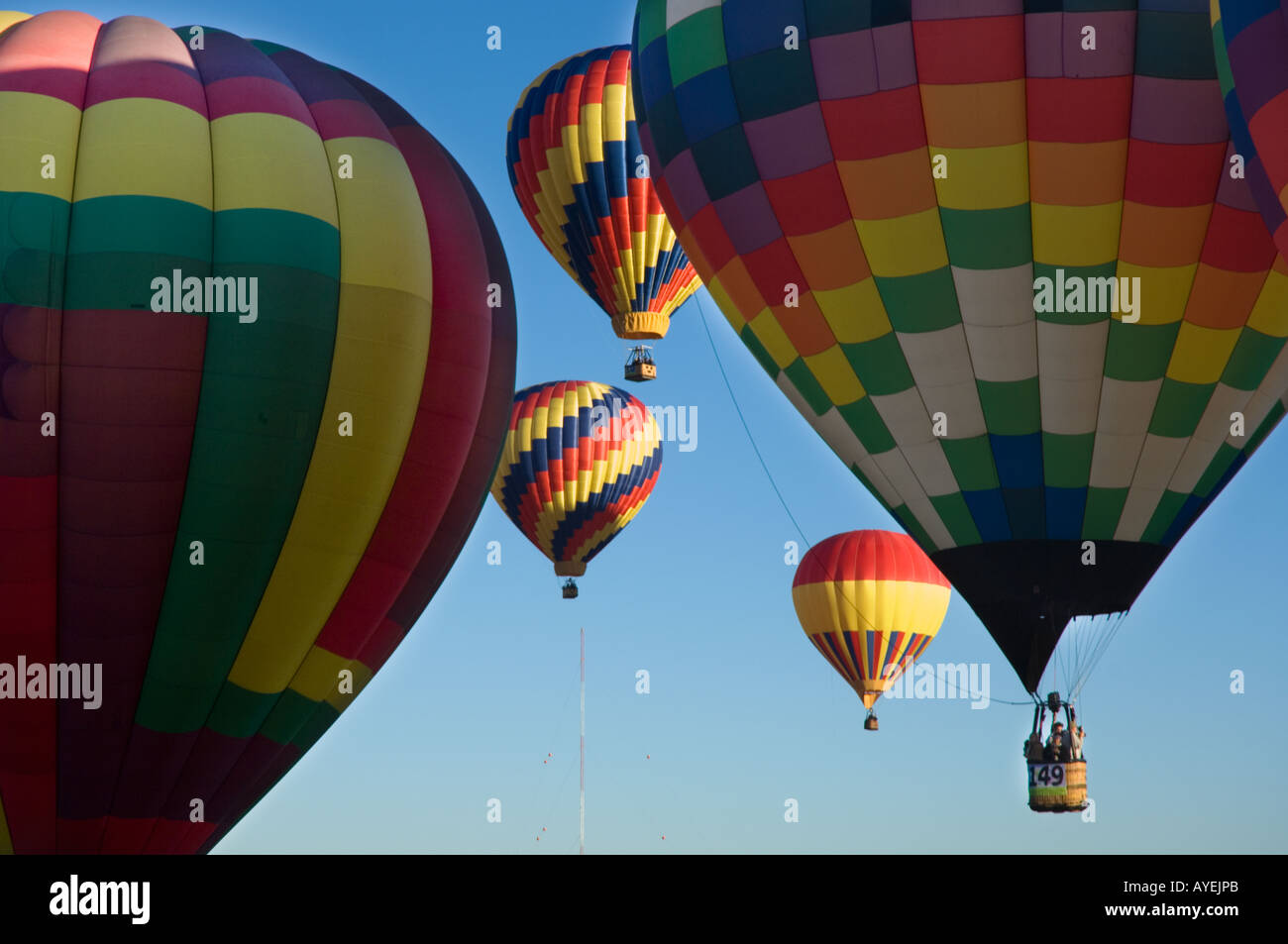 I palloni ad aria calda di lancio e in volo con il profondo blu del cielo e sunrise come sfondo. Balloon Fiesta di Albuquerque nel New Mexico Foto Stock