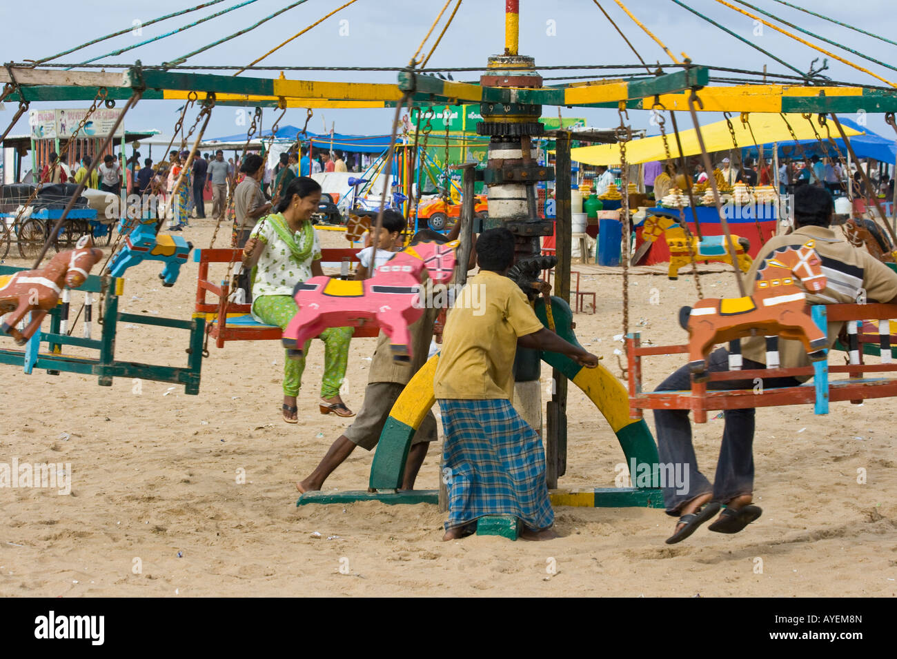 Due uomini manovella di un giro di divertimento in spiaggia in Chennai India del Sud Foto Stock