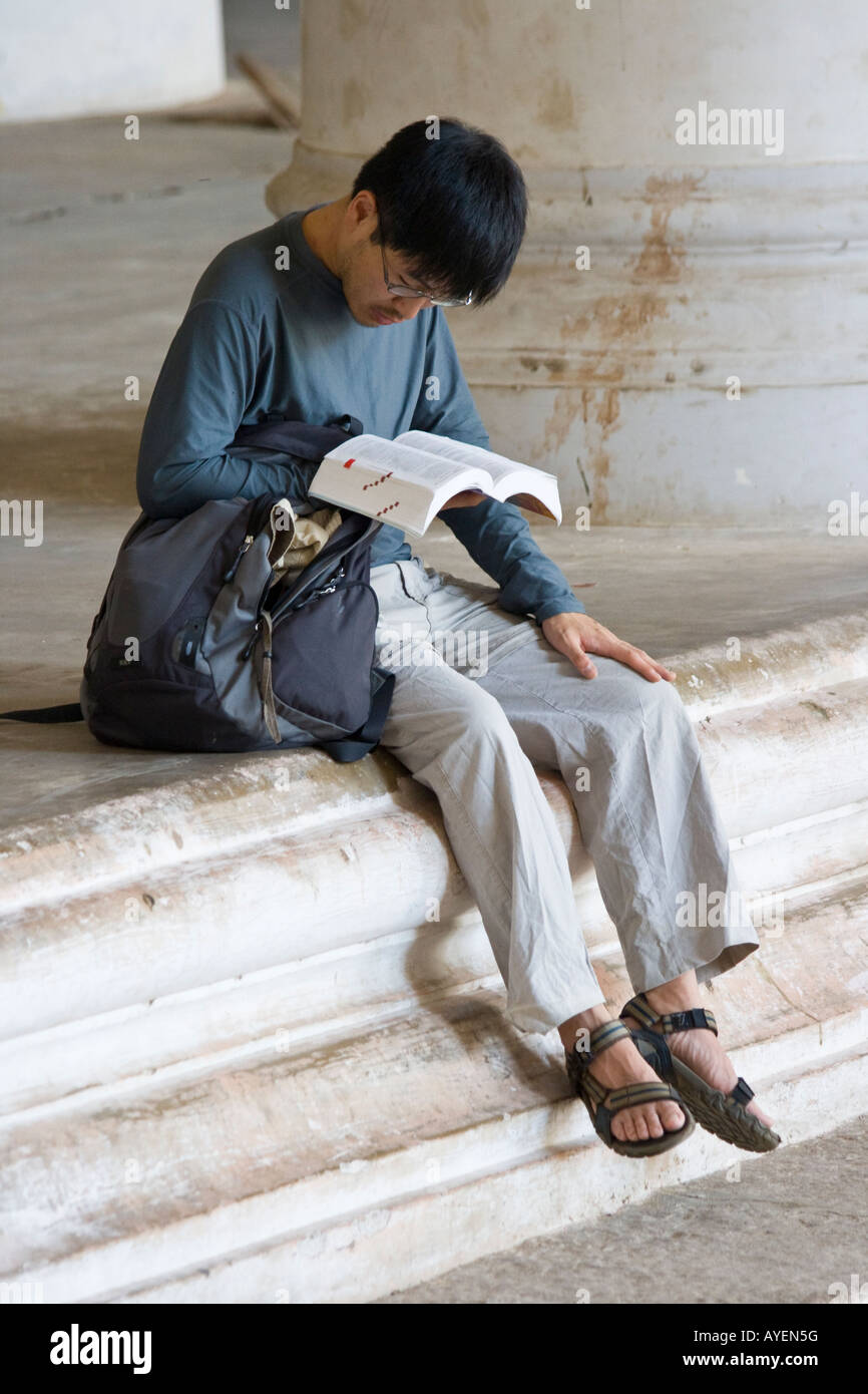 Il coreano Tourist leggendo un libro guida all'interno del Tirumalai Nayak Palace a Madurai India del Sud Foto Stock