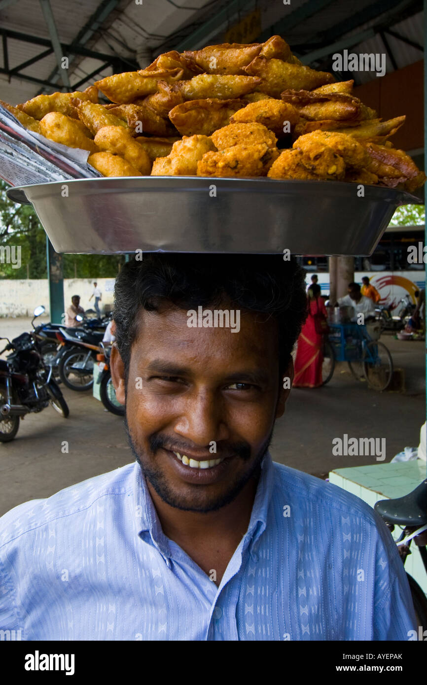 L'uomo vendere samosa e altri snack fritti alla stazione degli autobus in Pudukkottai India del Sud Foto Stock