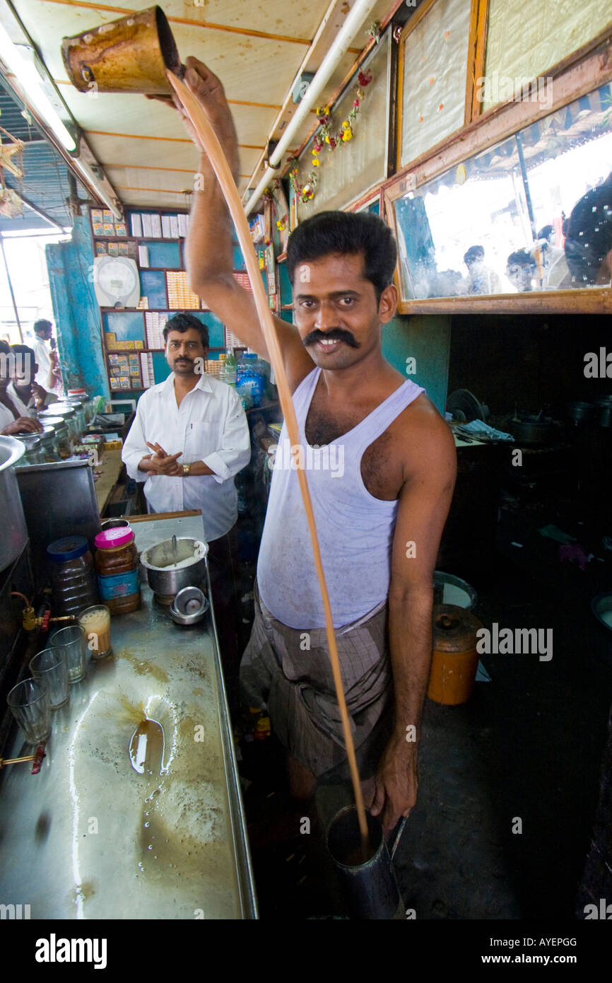 Uomo indiano rendendo Chai tè con una lunga versare in Tiruchirappalli o Trichy India del Sud Foto Stock
