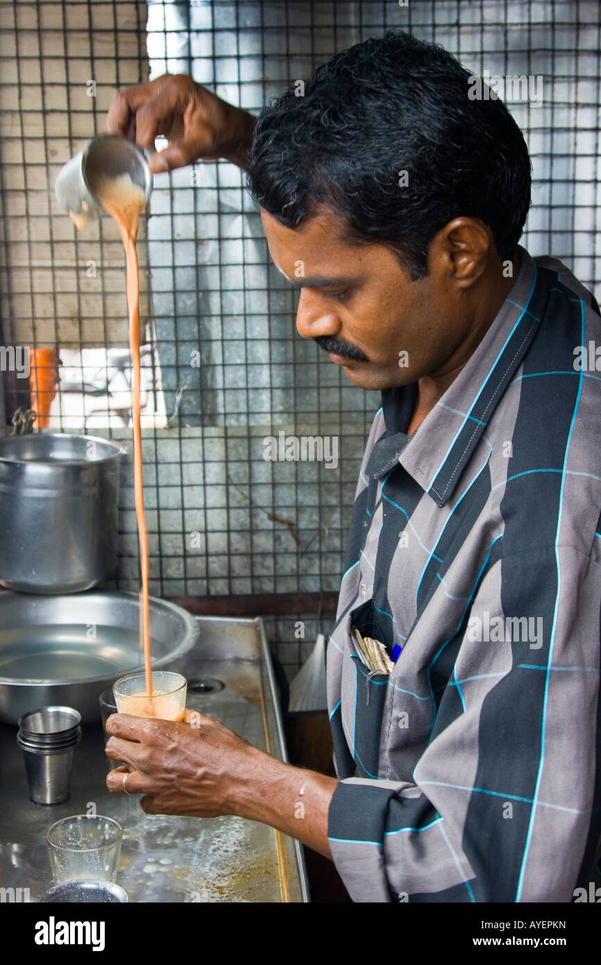 Uomo indiano rendendo Chai tè con una lunga versare in Thanjavur India del Sud Foto Stock
