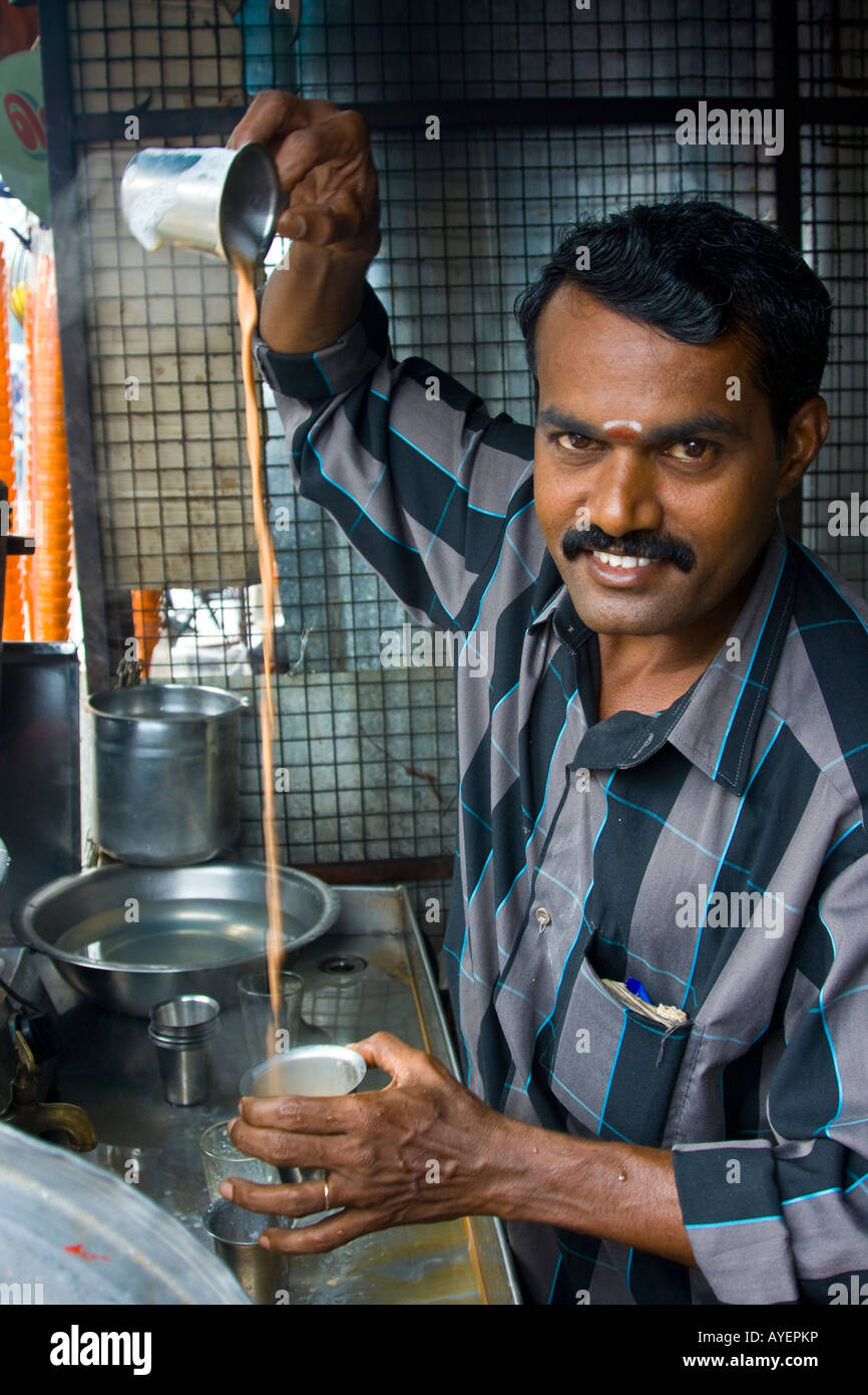 Uomo indiano rendendo Chai tè con una lunga versare in Thanjavur India del Sud Foto Stock