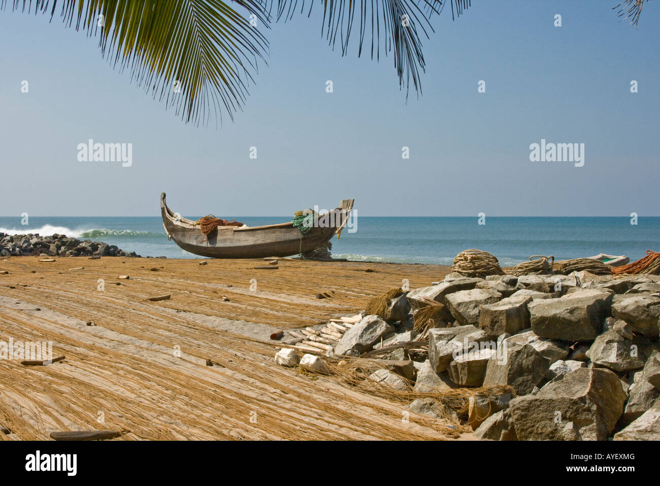 Reti di essiccazione al sole e barche da pesca sulla spiaggia di Varkala India del Sud Foto Stock