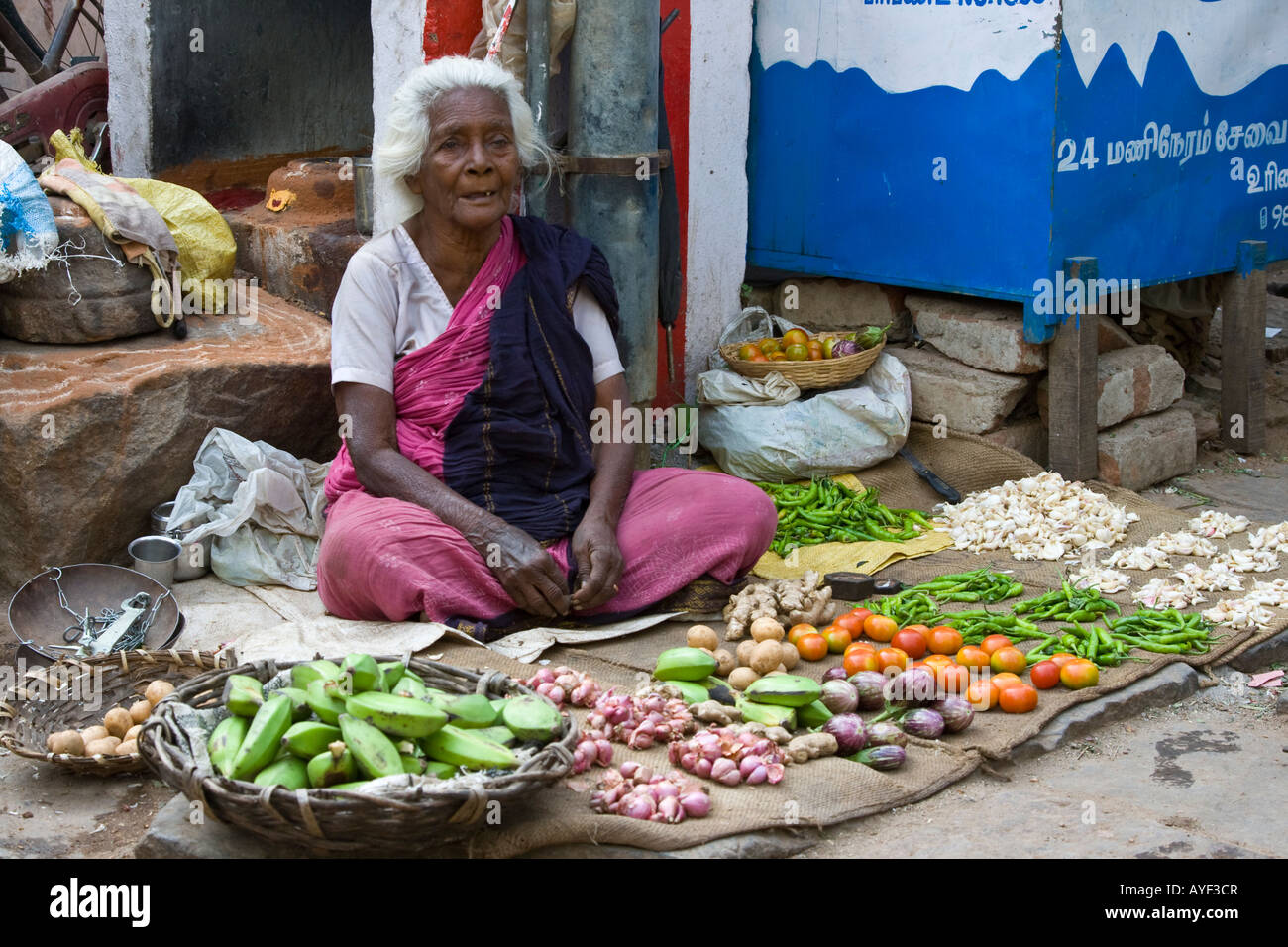 Donna anziana verdure di vendita in un mercato ortofrutticolo di Madurai India del Sud Foto Stock