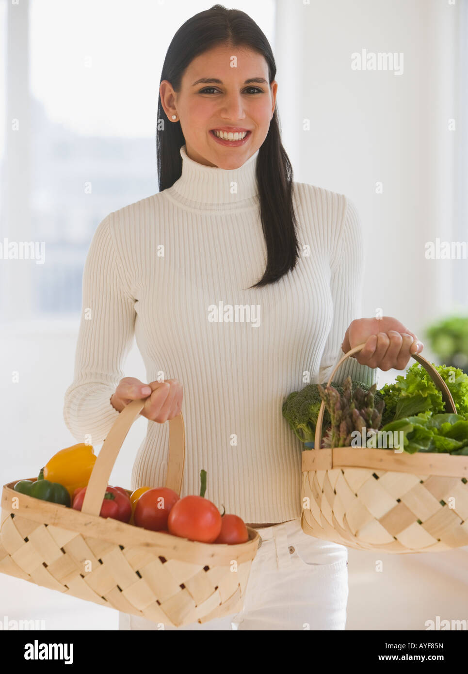 Donna che trasportano cesti di frutta e verdura Foto Stock
