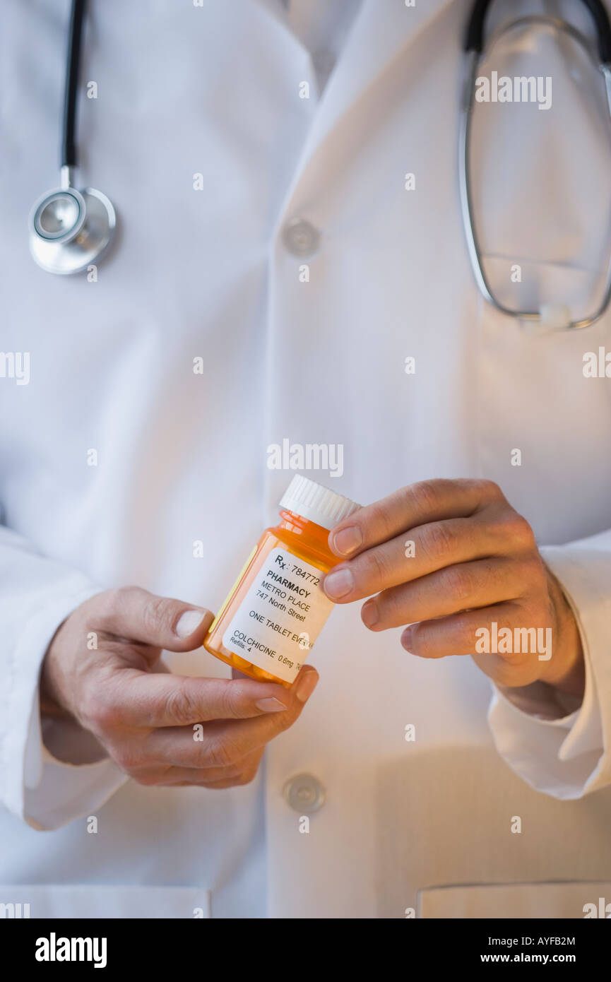 Medico tenendo la bottiglia di prescrizione Foto Stock