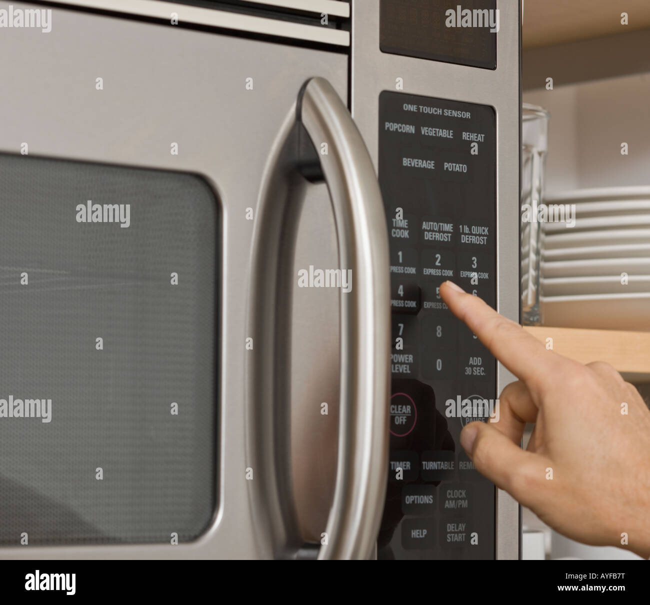 L'uomo spingendo il pulsante sul forno a microonde Foto Stock