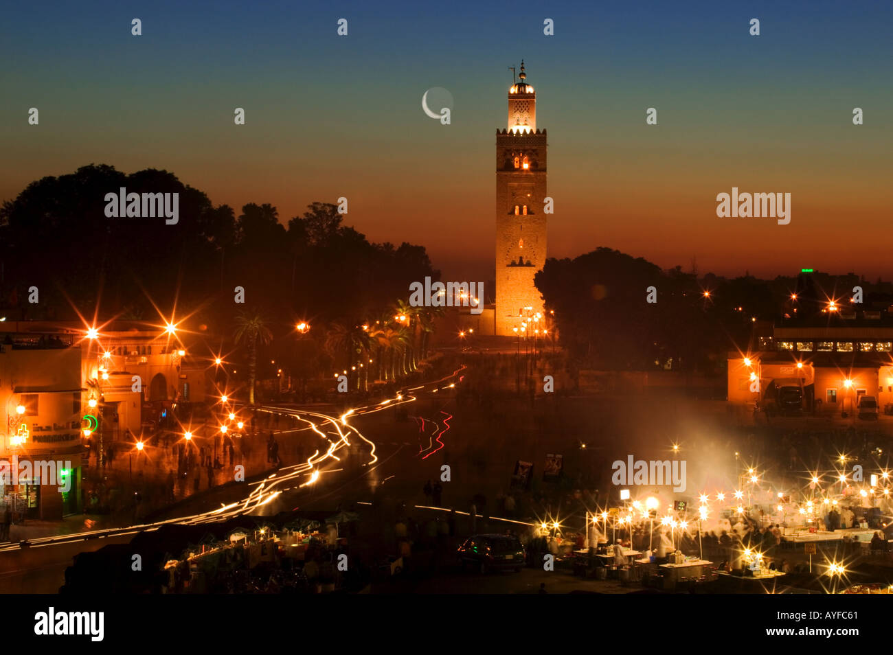 Vista sulla città di persone e le luci del Djemaa el Fna market place Moschea Koutoubia in background marrakech marocco Foto Stock