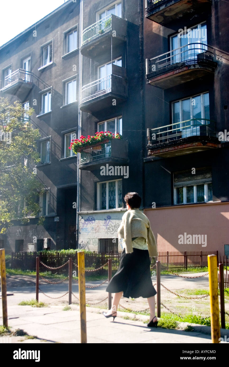 Donna che cammina da comunista prefabbricate costruite case Blok. Lodz Polonia centrale Foto Stock