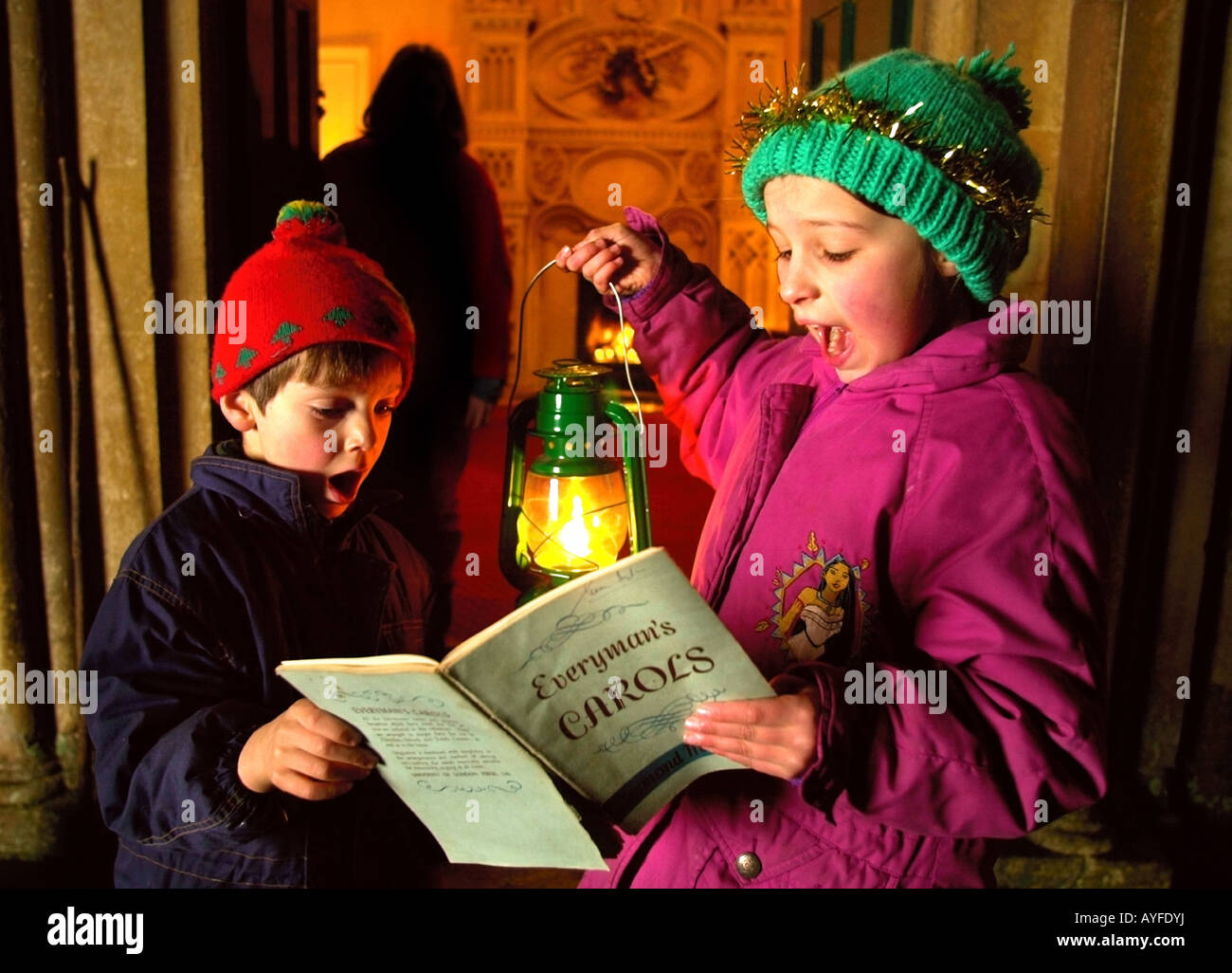 I bambini a cantare i canti natalizi in una casa di campagna Foto Stock