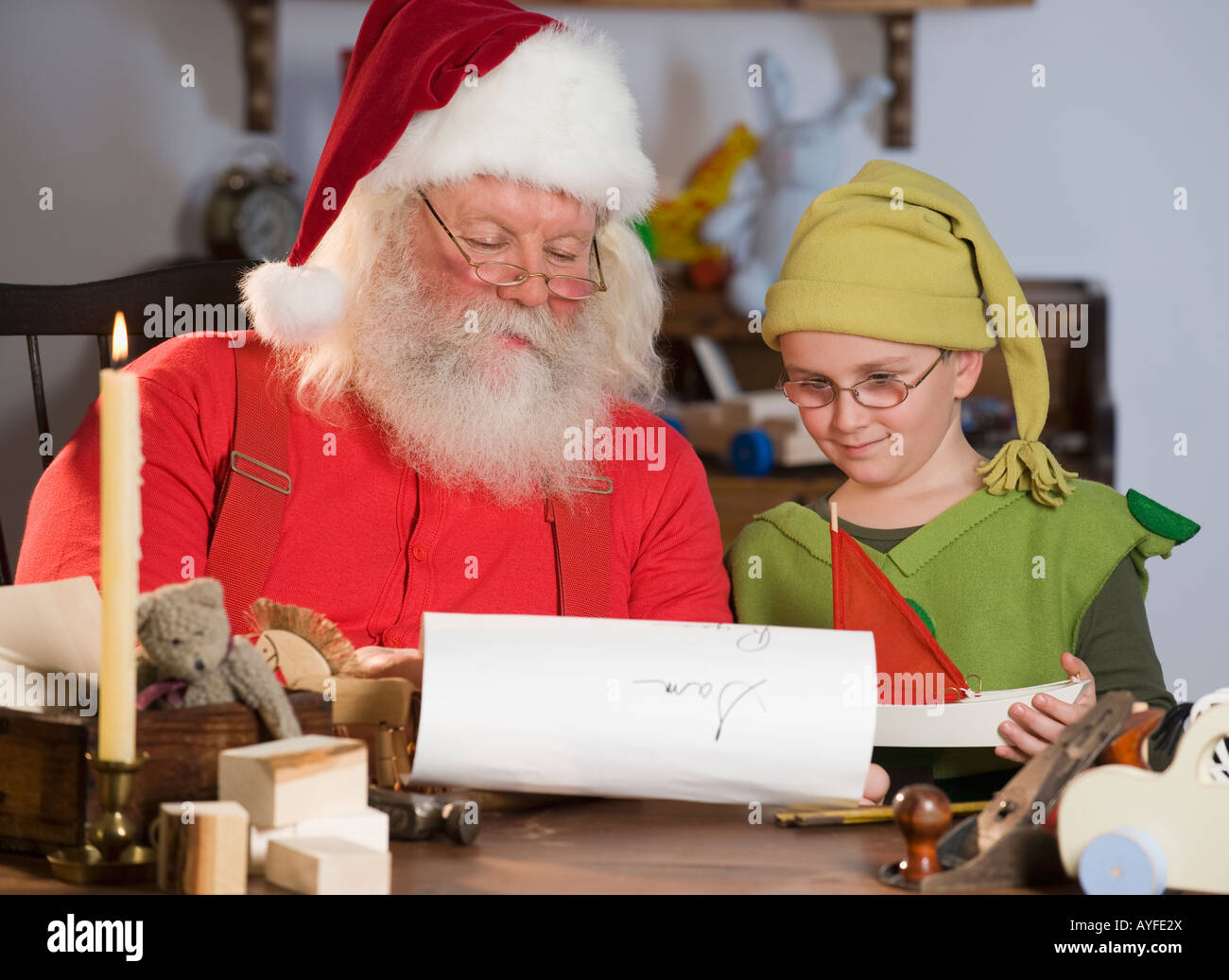 Santa Claus e elf elenco lettura dei nomi Foto Stock