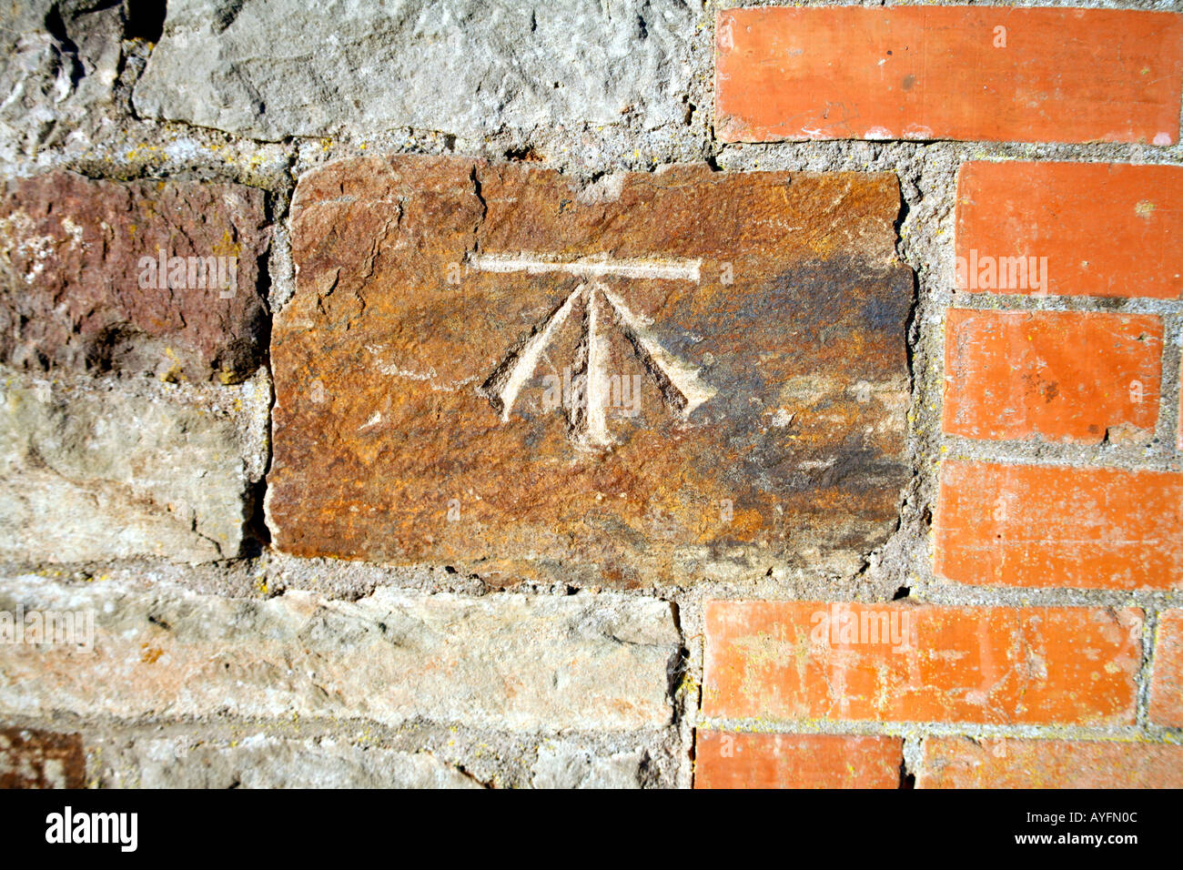 Ordnance Survey Benchmark incisa sulla pietra nel muro di mattoni Foto Stock