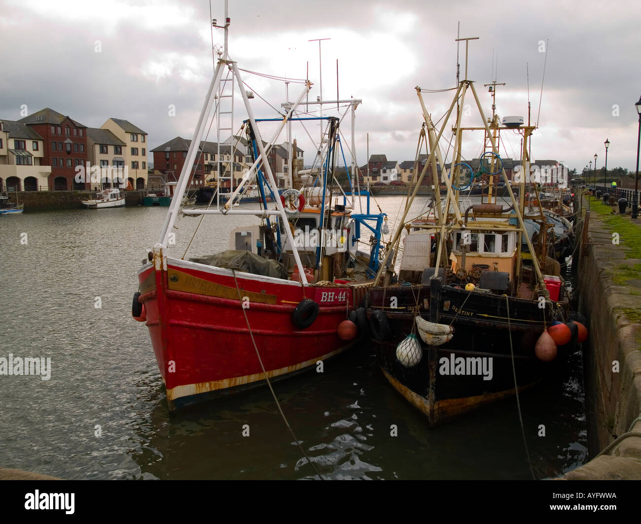 Waterside moderno alloggiamento e tradizionali barche da pesca a Maryport Cumbria Regno Unito Foto Stock