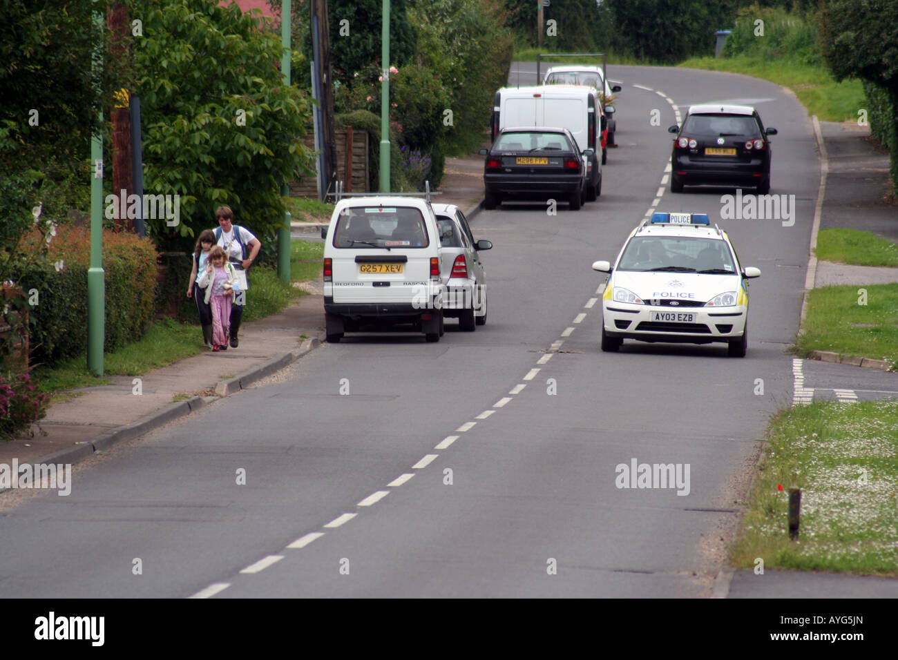 Una macchina della polizia si avvicina in una tranquilla cittadina di Suffolk Foto Stock