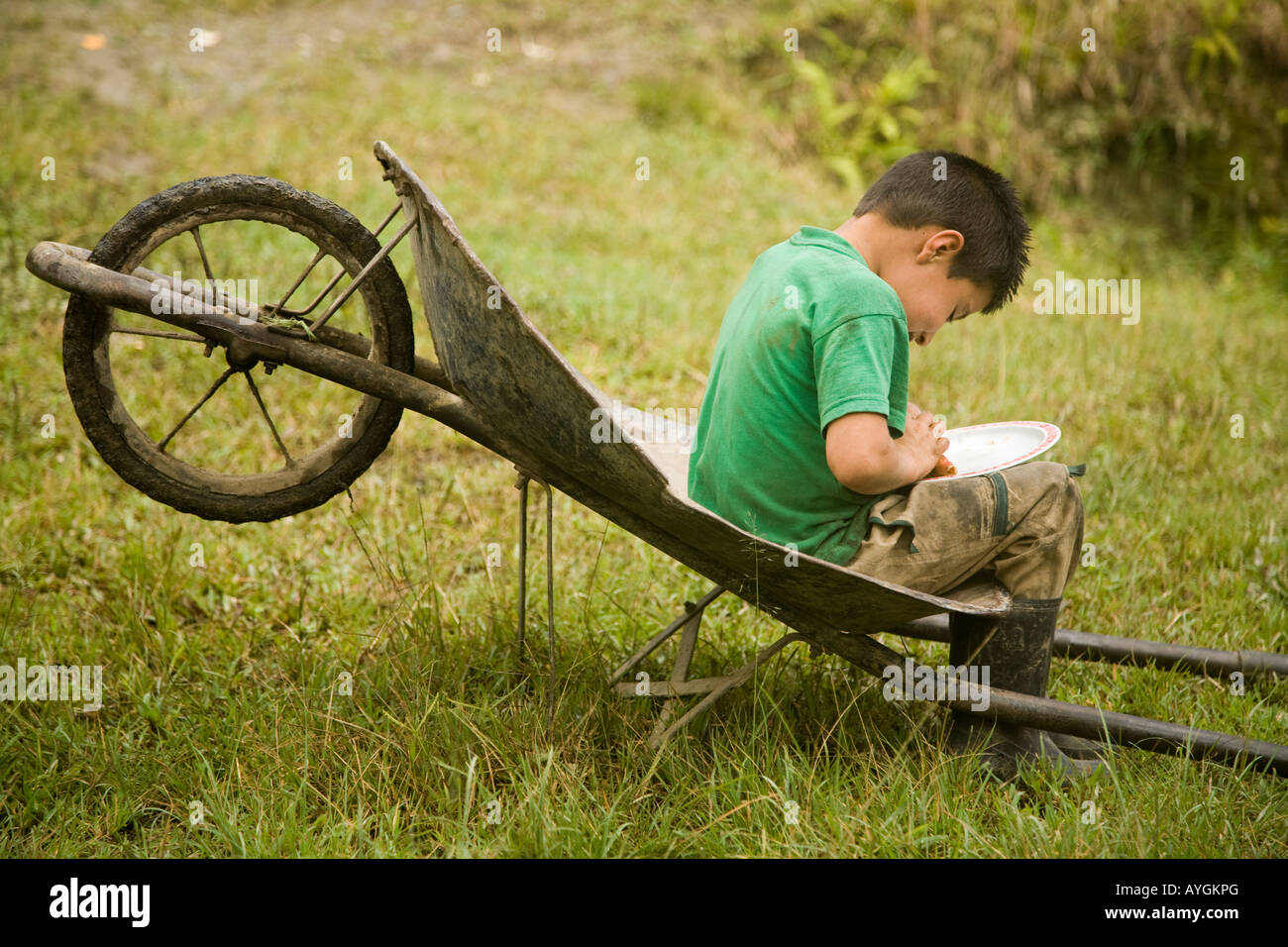 Un piccolo ragazzo di mangiare il suo pranzo fuori da una carriola, San Agustin, Colombia Foto Stock