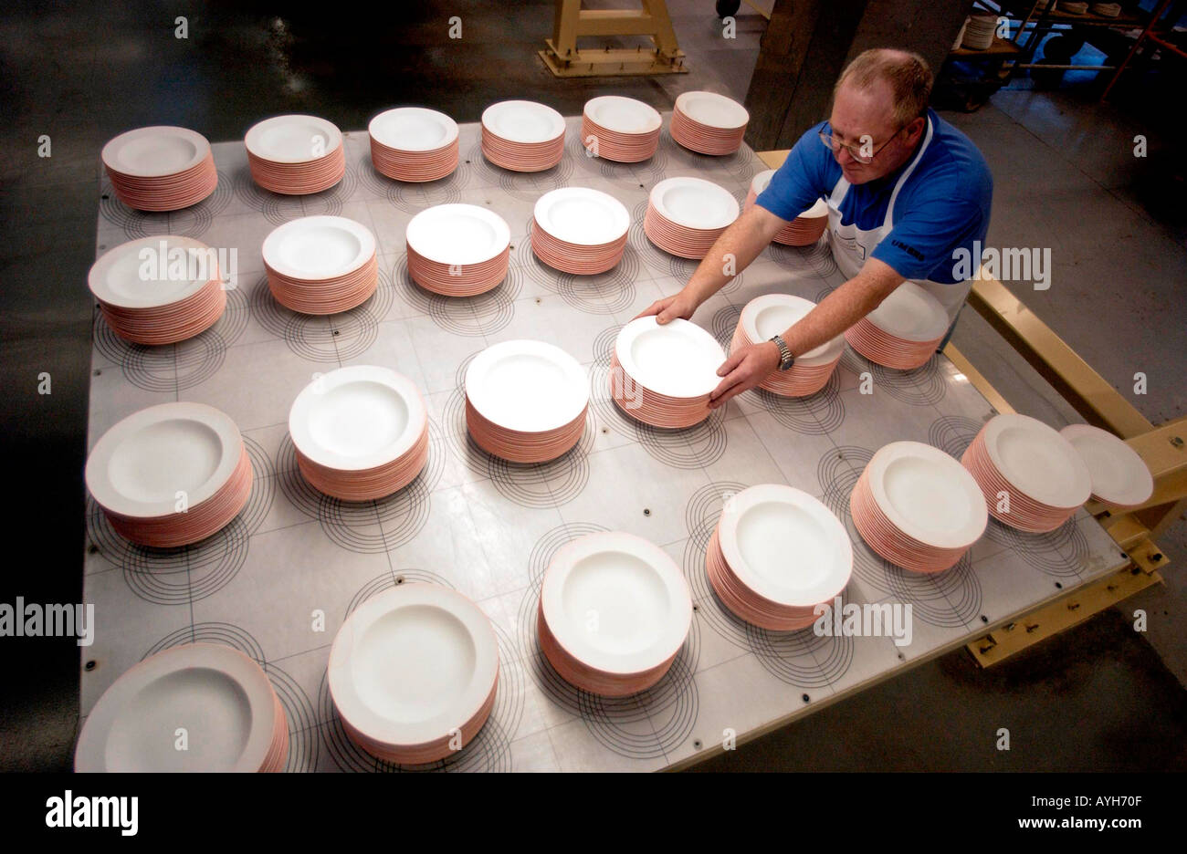 Un lavoratore con lastre prodotte al Wedgewood e fabbrica di ceramiche a Stoke on Trent Inghilterra UK Gran Bretagna Foto Stock