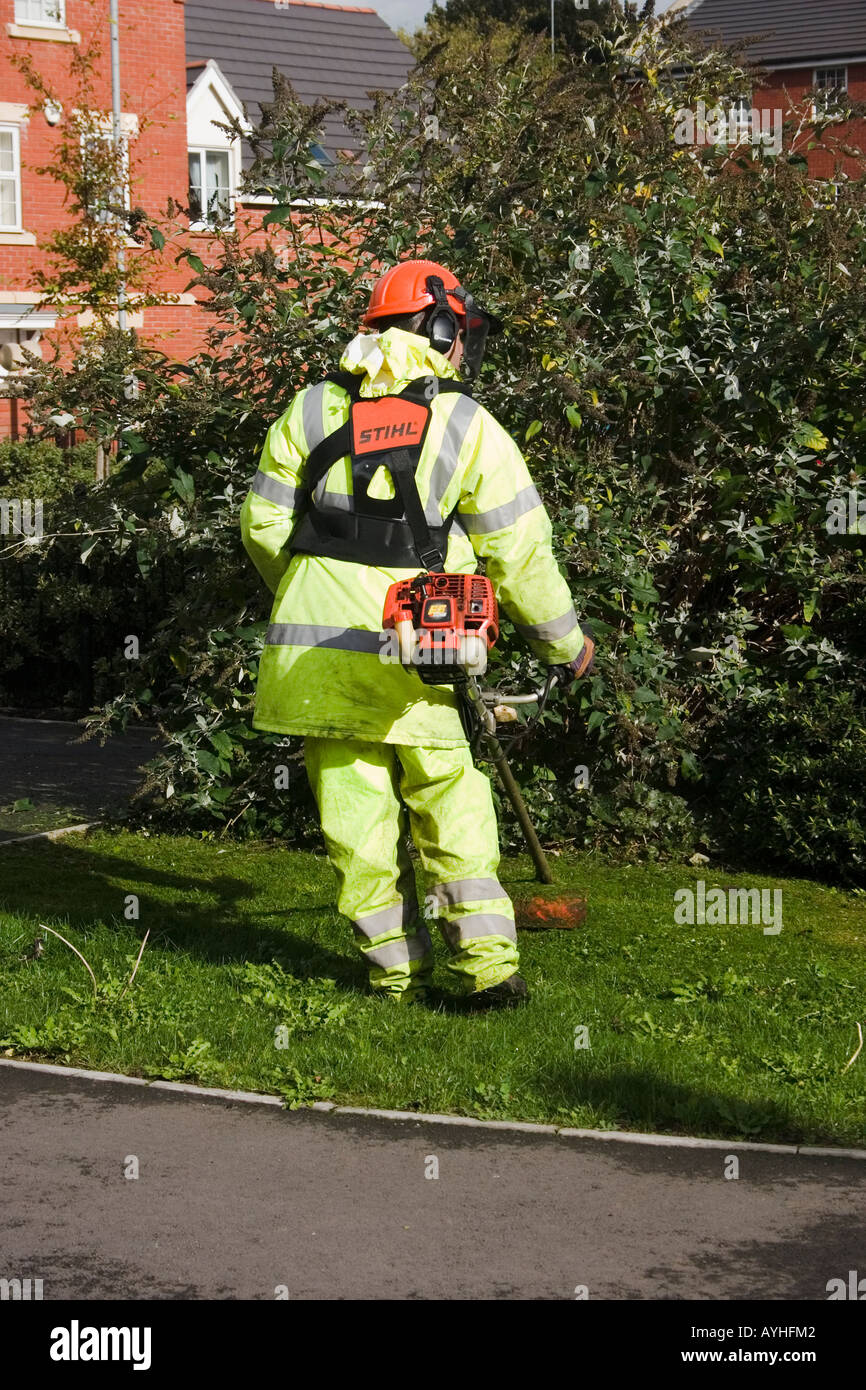 Workman strimming erba sconfinano Cardiff Regno Unito Foto Stock