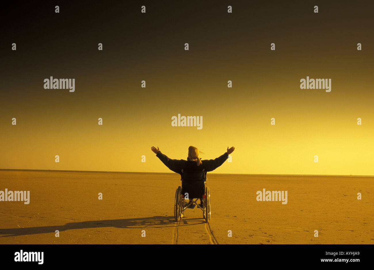 Mann erfaehrt Freiheit im Rollstuhl un einem Strand Foto Stock