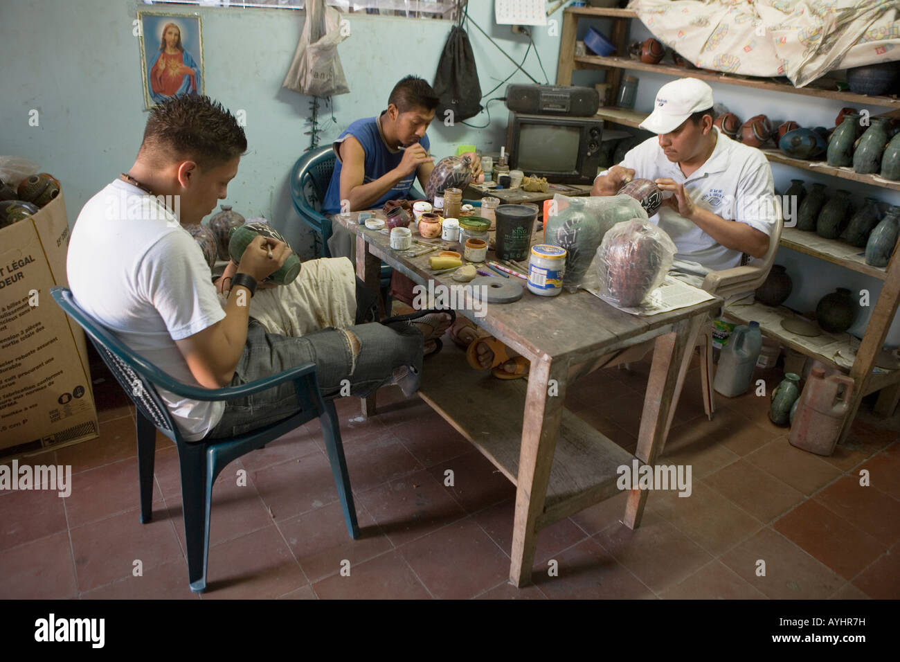 Gli uomini la pittura di progetti su pentole in un laboratorio di ceramiche San Juan de Oriente Nicaragua Foto Stock