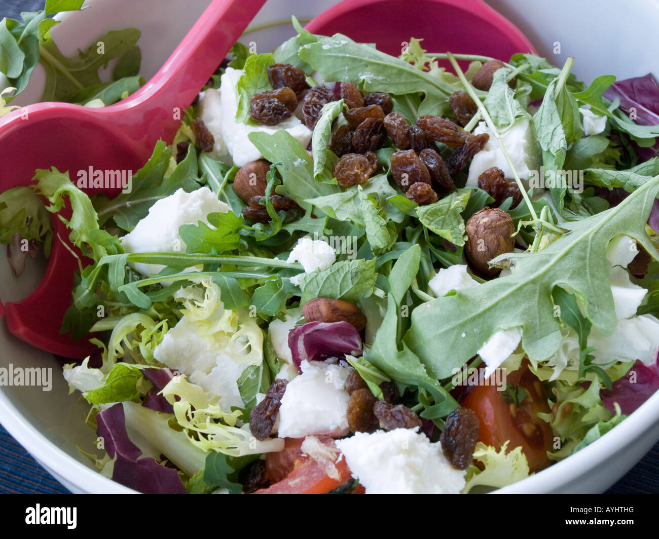 Cibo sano, Insalata verde con formaggio pomodori e uva passa in una ciotola Foto Stock