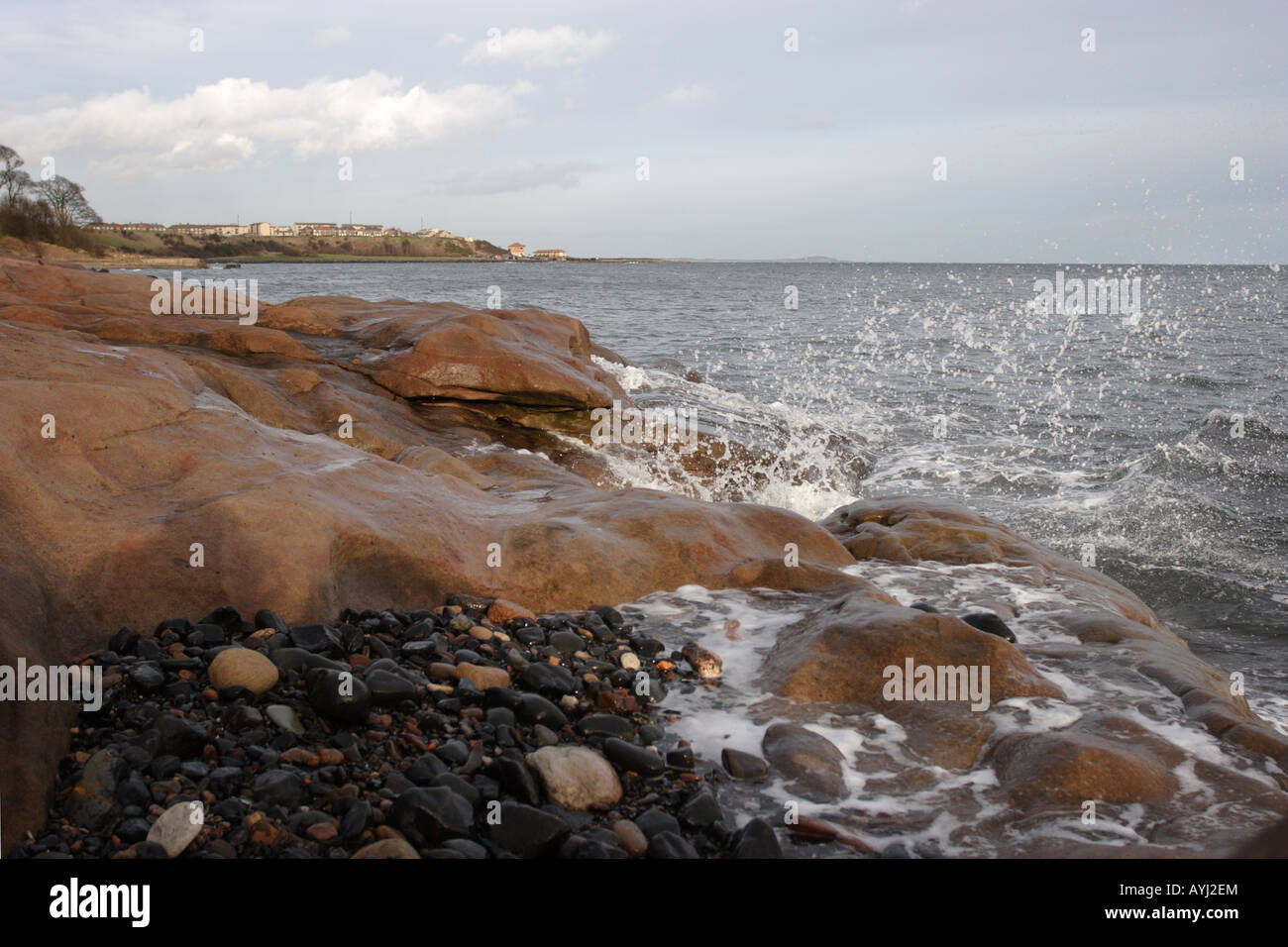 Onde che si infrangono sulla spiaggia rocciosa del Fife Coast a ovest di Buckhaven Foto Stock
