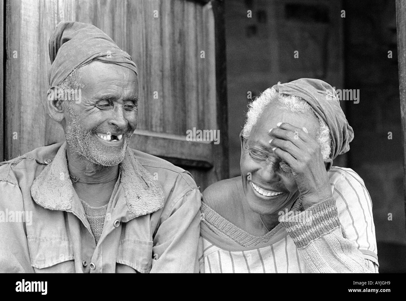 Ritratto B/N di una coppia felice e ridente anziana alle porte della loro casa di recente costruzione in una zona della baraccopoli di Addis Abeba. Etiopia, Africa Foto Stock