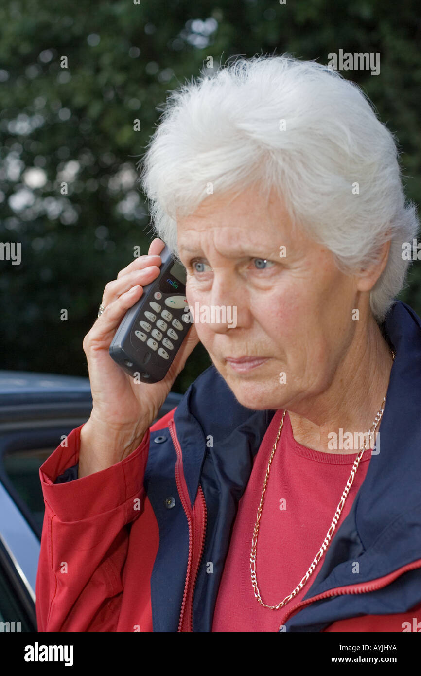 Close up elederly donna parlando sul vecchio telefono cellulare Nokia UK Foto Stock