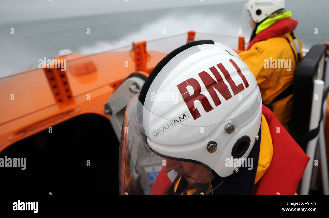 Il RNLI equipaggio sulla classe Tamar scialuppa di salvataggio prendere per mari tempestosi, fuori del litorale britannico Foto Stock
