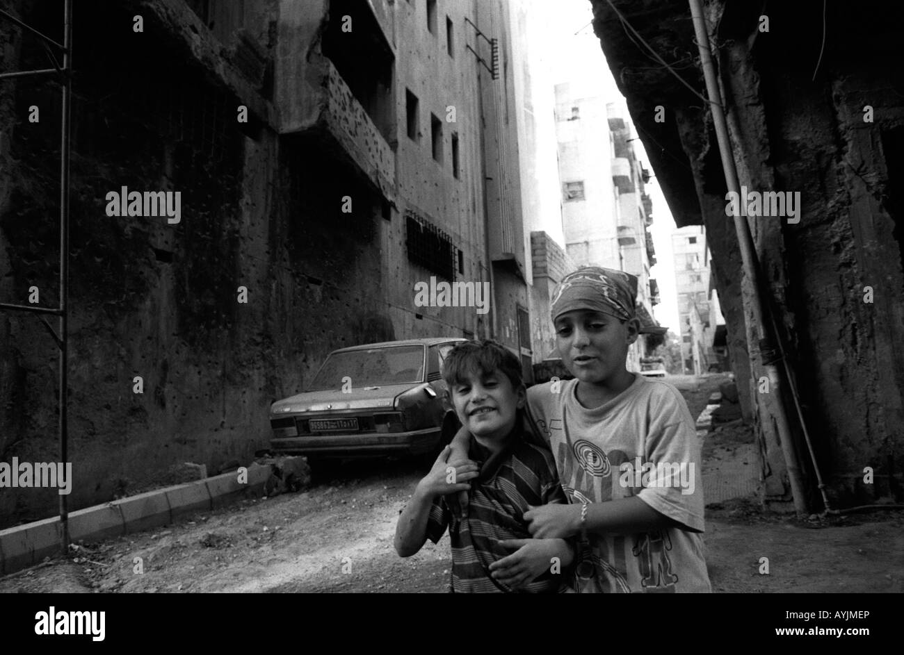 Ragazzi giocare in una scarsa backstreet abbandonati a sinistra dalla lunga guerra civile a Beirut, Libano Foto Stock