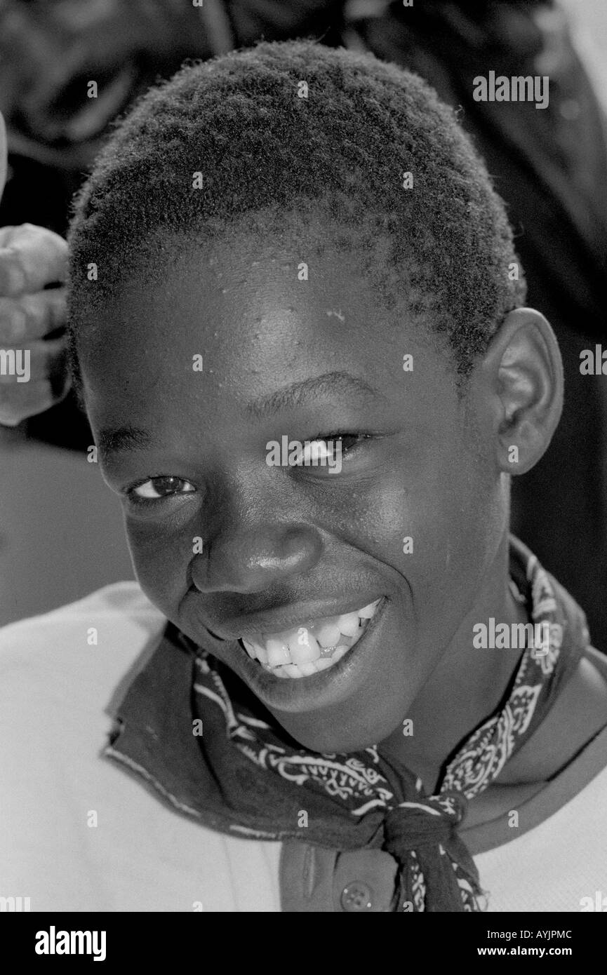 B/N Ritratto di un ragazzo di strada sorridente, iscritto in una speciale classe scolastica per migliorare le sue possibilità di vita. Kingston Giamaica Foto Stock