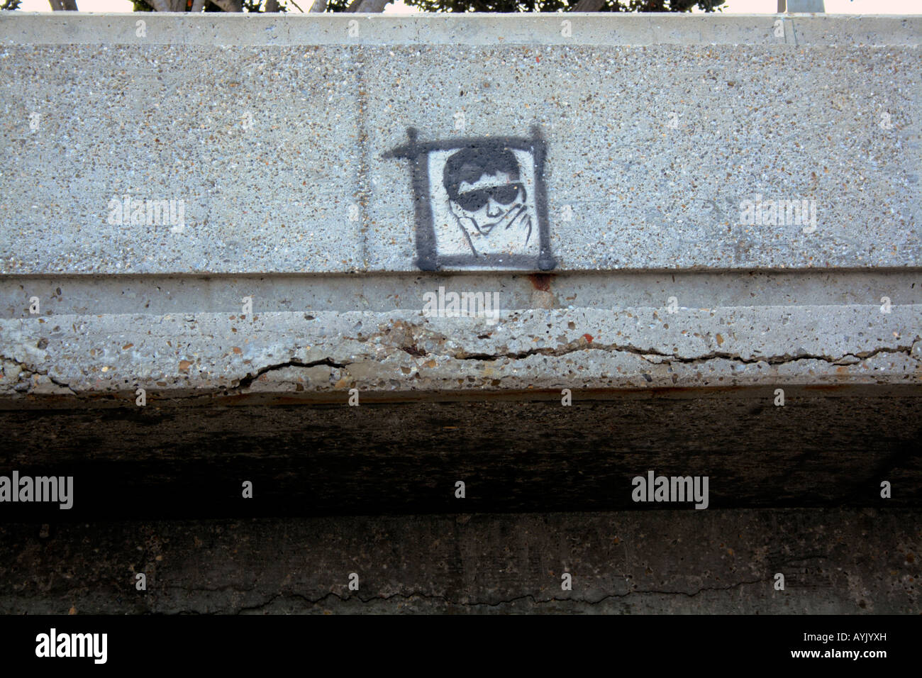 Stampata graffiti su un calcestruzzo di cracking seawall. Foto Stock