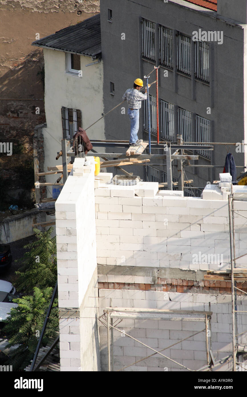 Operaio edile lavorando su un edificio alto. Galata, Beyoglu, Istanbul, Turchia Foto Stock