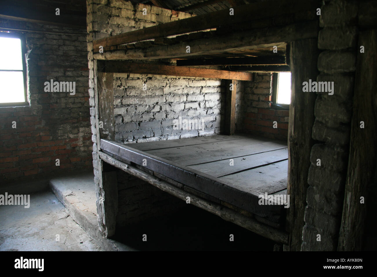 Un tipico mattone e legno piattaforma di sonno in un capanno originale nell'ex campo di concentramento nazista di Auschwitz Birkenau. Foto Stock