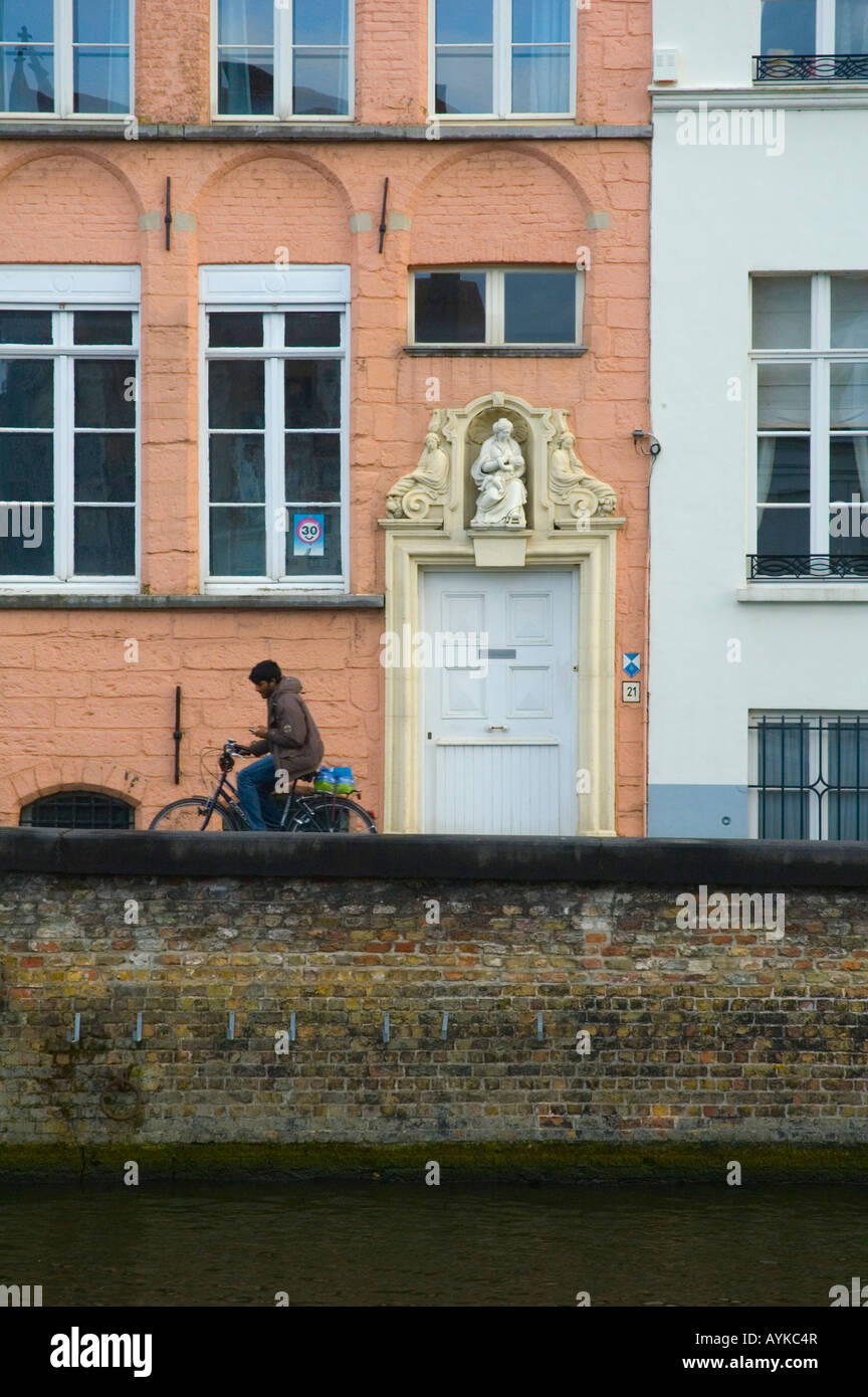 Uomo in sella ad una bicicletta e utilizzando il suo telefono cellulare in Bruges Belgio Europa Foto Stock
