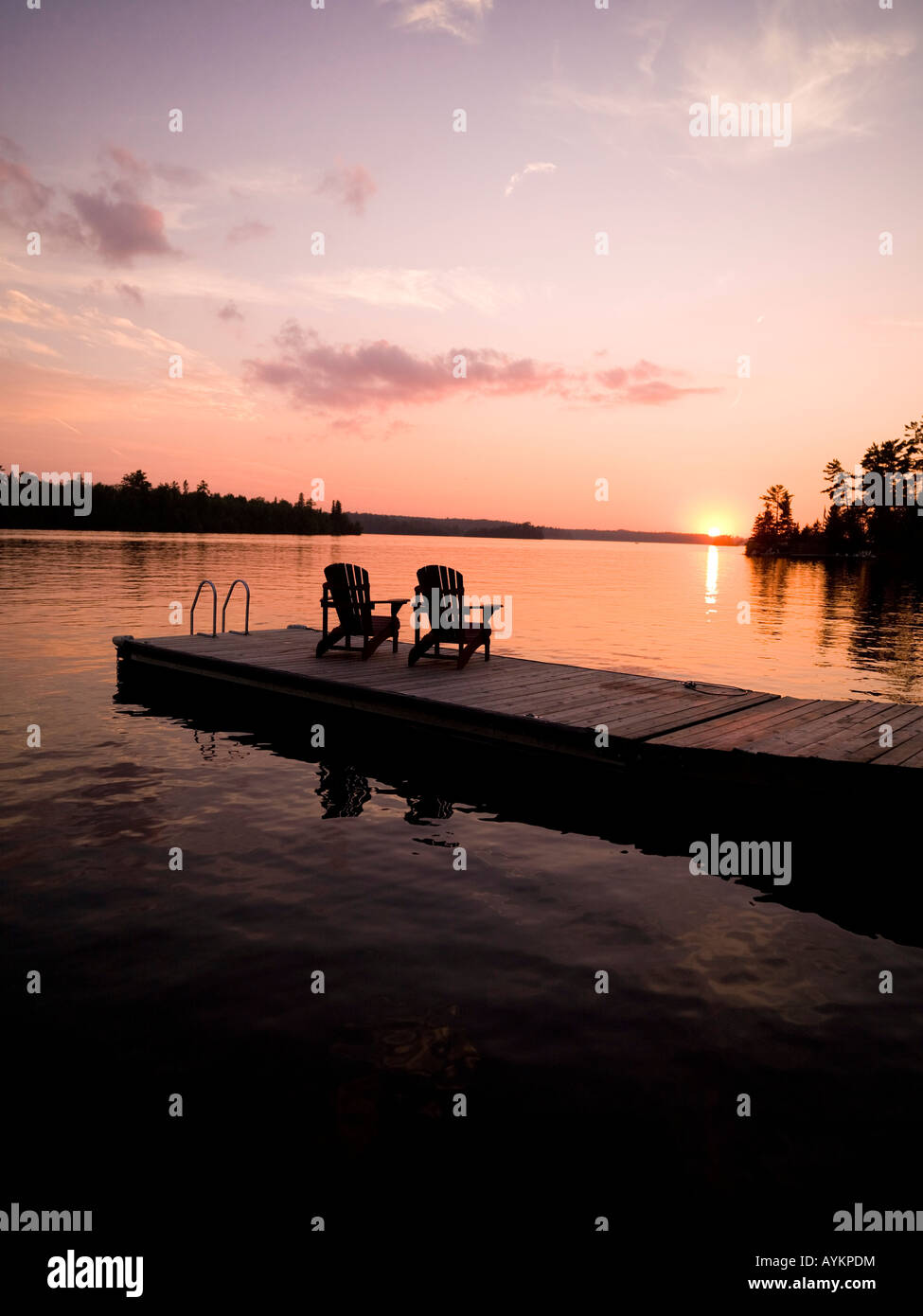 Il lago dei boschi, Ontario, Canada, sedie Adirondack su un dock Foto Stock