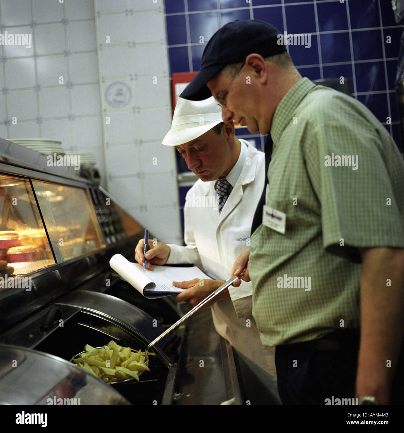 Un ispettore di cibo in un chip shop Foto Stock