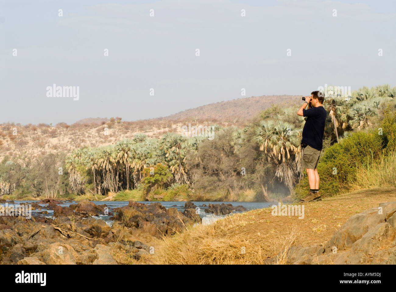 Per turisti in cerca attraverso il binocolo, Epupa Falls Namibia sul confine angolano Foto Stock