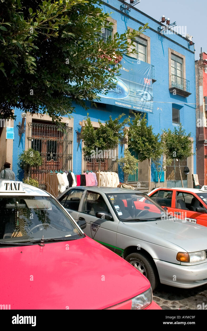 Taxi e auto parcheggiata proprio di fronte a un luminoso edificio blu a San Angel Città Del Messico Foto Stock