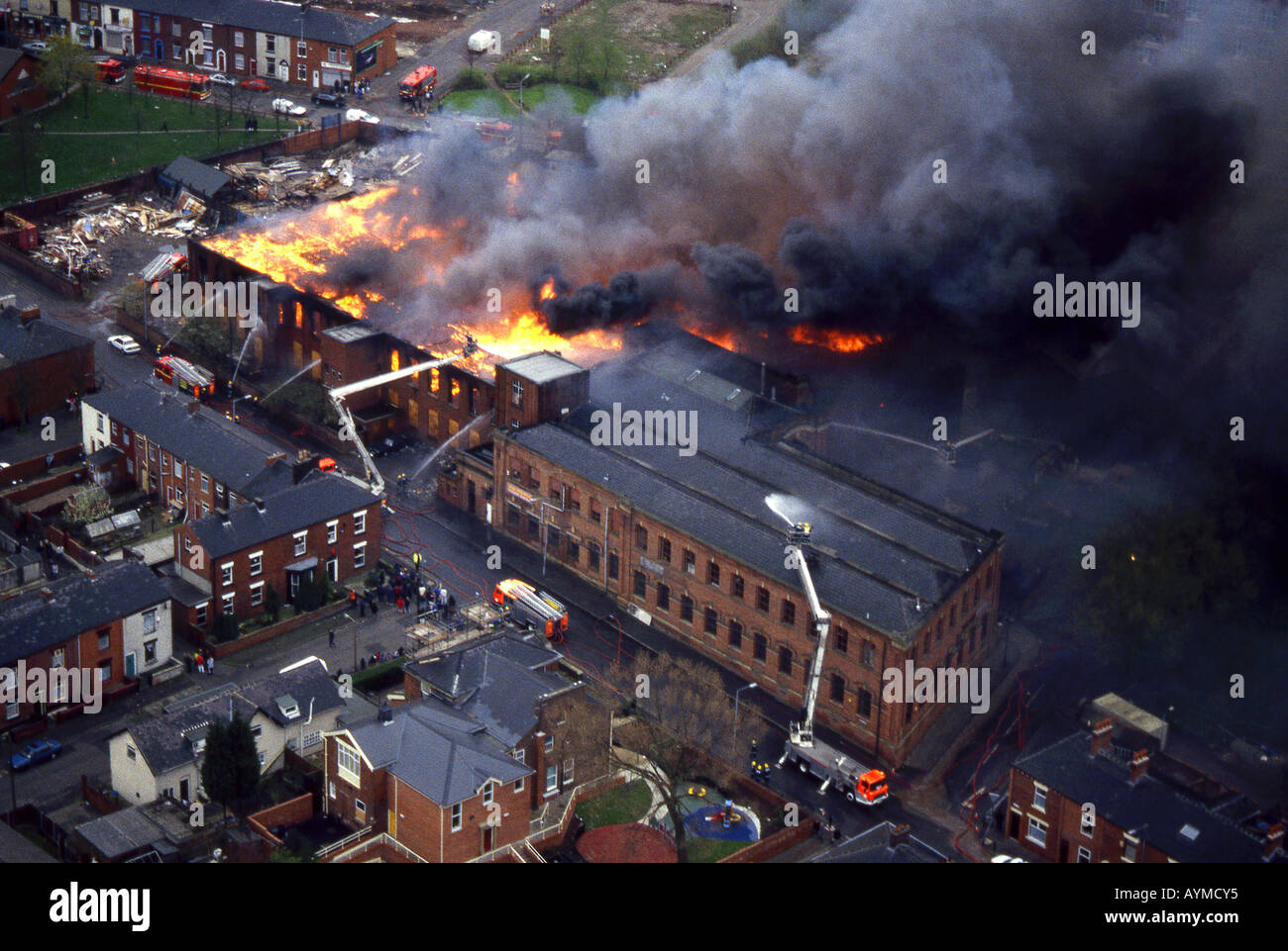 Vista aerea di un grande incendio del Mulino circondato da case, Greater Manchester, Inghilterra, Regno Unito Foto Stock